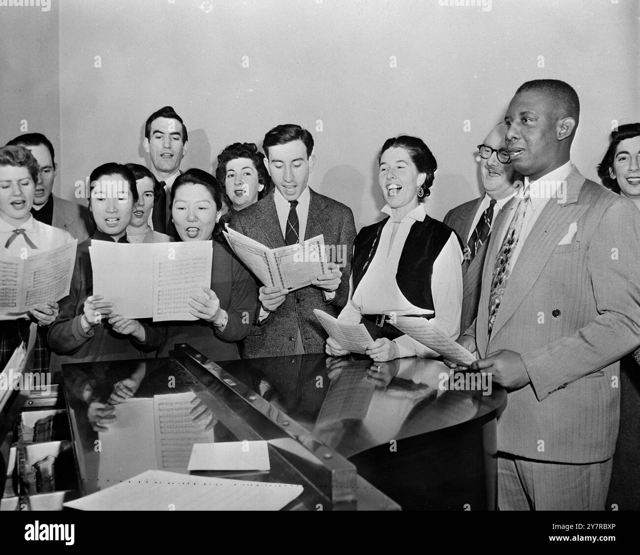 CANTATE UNA CANZONE DI FRATELLANZA. 18.2,54. New York. Gli statisti possono lanciare arpioni verbali l'un l'altro nelle Nazioni Unite, ma c'è un dipartimento in cui l'armonia prevale sempre. E' nell'UN. Glee Club. Composto da cantanti provenienti da molte terre ma tutti nemici inveterati della discordia, con la settimana della Fratellanza appena dietro l'angolo (21-28 febbraio) i cantautori delle Nazioni Unite potrebbero servire da esempio brillante per il resto del mondo. Il gruppo canta selezioni in francese, inglese, spagnolo ed ebraico e non solo si esibisce alle funzioni delle Nazioni Unite, ma anche in molte scuole. LE FOTO I.N.P. MOSTRANO: Da le Foto Stock