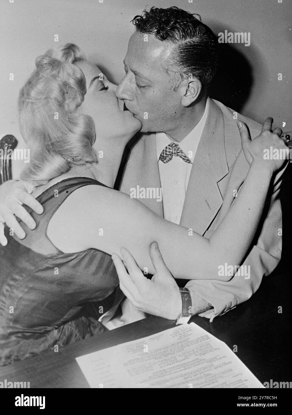 CINQUE MINUTI T.V. BACIO> - POI IL SACCO. 18.2,54. (Immagine dalla radio). Solo un bacio è costato il disc jockey Jack Eigen, 38 anni, il suo lavoro. È durato cinque minuti - e sembrava un'eternità agli spettatori imbarazzati dello show televisivo di Jack da Chicago. La ragazza abbracciata nel bacio T.V. più lungo del mondo per testare la reazione del pubblico è stata la star di Hollywood Cleo Moore, 19 anni. Anche se era stata assolta dalla colpa per l'incidente, Cleo stava arrossando e frettolando perché "la reazione non era un po' quella che ci aspettavamo". Il contratto di Jack era stato concluso per volgarità, abbondanza e cattivo gusto. N.I. Foto Stock