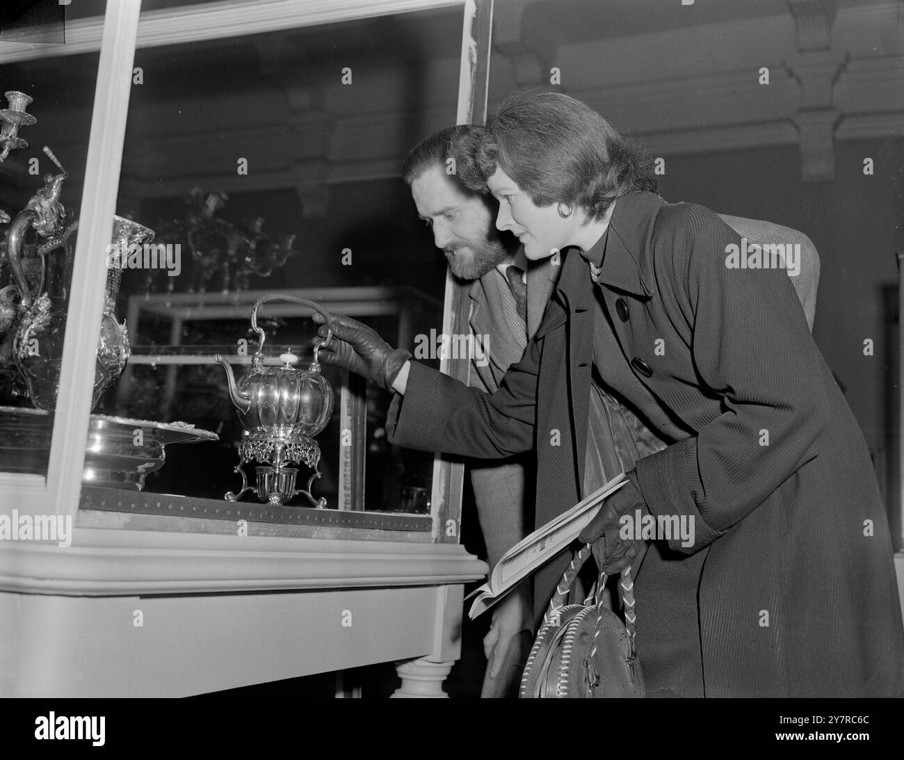 TARGA REALE DA BUCKINGHAM PALACE E IL CASTELLO DI WINDSOR IN MOSTRA 18.2,54. La targa reale di Buckingham Palace e del Castello di Windsor è stata vista oggi in una mostra privata presso il Victoria and Albert Museum. I pezzi sono stati prestati da sua Maestà mentre è in tour e saranno esposti ad una mostra pubblica a partire da domani. LE FOTO DI I.N.P. MOSTRANO il signor e la signora Frederick Paul di Earl's Court che guardano un bollitore e un banco da tè dorati che un tempo apparteneva a Federico Principe di Galles. Foto di Joe Waldorf 74624 International News Photo (7). Foto Stock