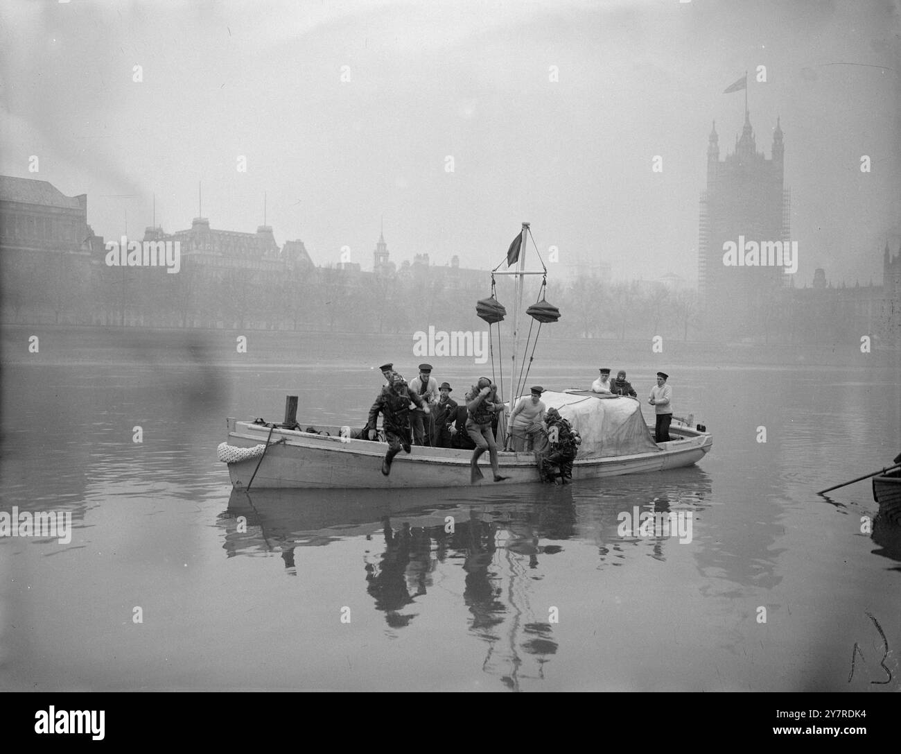 BRRRRR! 28.154. I subacquei della Royal Naval fanno per la prima volta esercitazioni di addestramento sotto il Tamigi. Il loro lavoro viene svolto in acque torbide sul letto del fiume da sotto la piscina di Londra a Battersea. L'obiettivo della loro visita è quello di offrire loro un'esperienza subacquea in condizioni che di solito prevalgono nelle acque poco profonde dei porti commerciali e dei fiumi. I.N.P. Photo Shows: Una visione generale della scena di Lambeth che mostra un subacqueo in arrivo e un frogman e un altro subacqueo in entrata. Foto di R. Palmer. EM/74215. Foto di notizie internazionali. Foto Stock