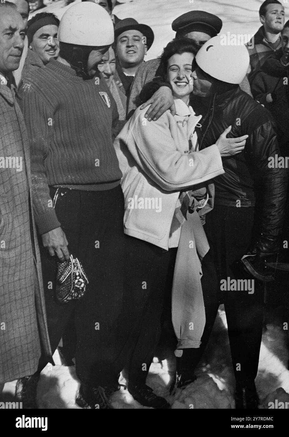 L'ITALIA VINCE I CAMPIONATI DI BOB A DUE UOMINI A CORTINA. Il 7 febbraio 1954, a Cortina d'Ampezzo, l'Italia ha vinto il suo primo campionato mondiale di Bob a due uomini battendo qui l'ingresso statunitense, con un record di corsa lungo lo scivolo ghiacciato di Cortina. La foto mostra i vincitori italiani che ricevono un bacio da una bella moglie. I vincitori sono G. Scheibmeier (a destra) e A. Zambelli. Foto di notizie internazionali. Foto Stock