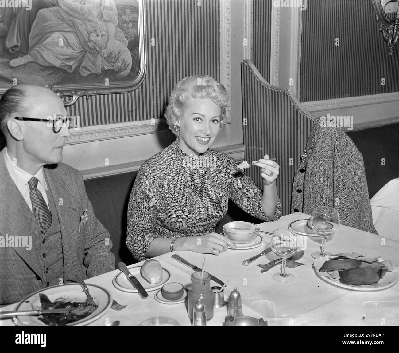 LA STAR DEL CINEMA FRANCESE MOSTRA ABITI PARIGINI IN TV. 23.1.54 la bellissima Martine Carol, una delle star del cinema francesi, è arrivata da Parigi ieri sera per apparire al Tonight's TV's Cafe Continental. Lo spettacolo fornirà agli amanti della moda alcune nuove idee su ciò che le donne indossano a Parigi. Miss Carol sarà vestita dal couturier di Parigi Jacques Heim. Ora sta girando un film a Parigi "il letto". Si ritiene che guadagni £ 100.000 per ogni film che fa. I.N.P. Photo mostra la signorina Carol, pranzando al ristorante francese Pere Aguste, Londra. Foto di J. Davies. 74045. EM International News Photos. Foto Stock