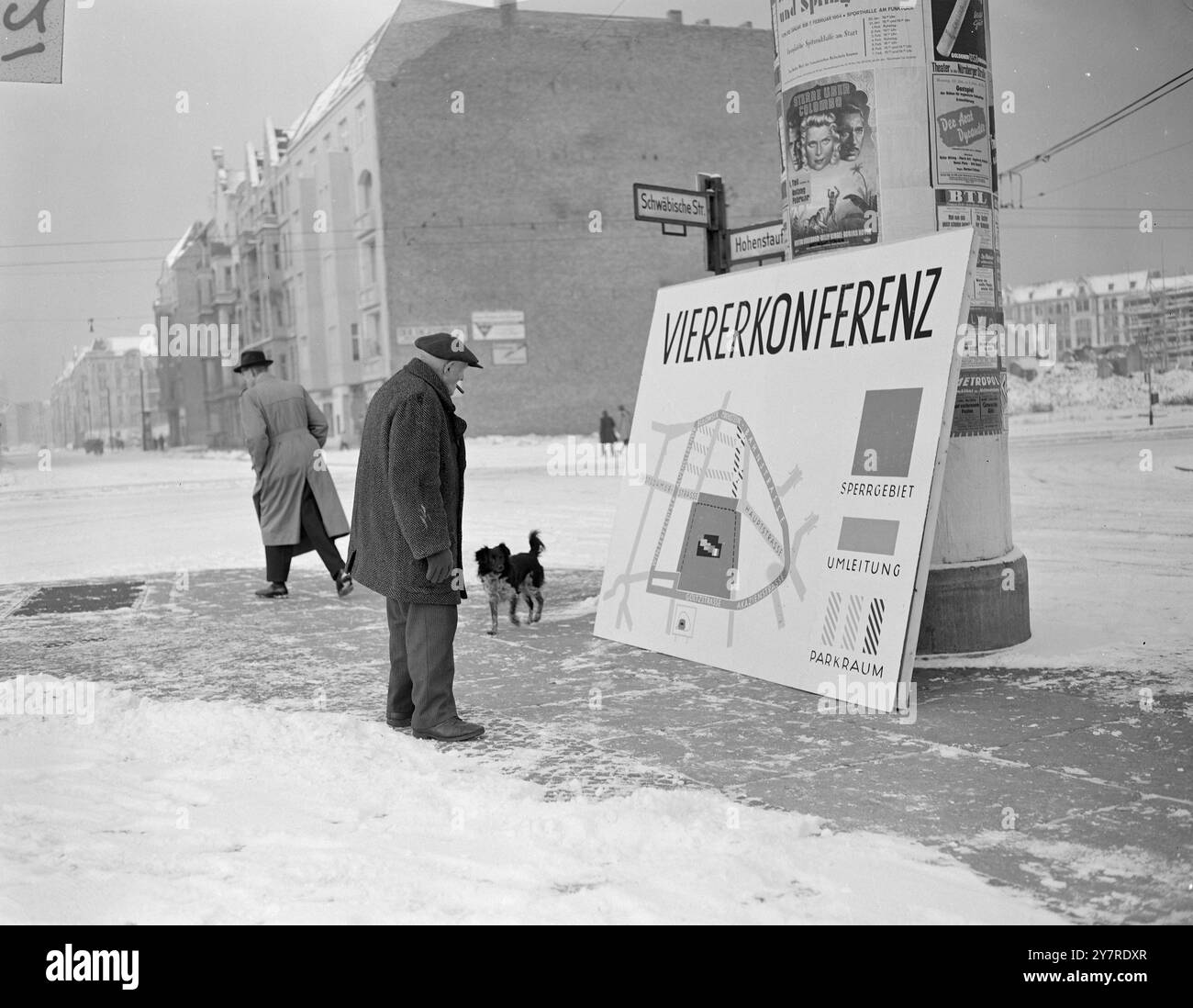 BERLINO OVEST SI PREPARA ALLA GRANDE CONFERENZA 1.24.54. Il traffico è stato deviato intorno all'edificio dell'ex Allied Control Authority, dove si terranno le prime e le terza settimane della Big Four Conference. La foto dell'INP mostra un vecchio berlinese, con il suo cagnolino, che sembra piuttosto perplesso davanti a un poster delle strade bloccate intorno all'edificio della conferenza. Il poster che mostra l'area ombreggiata chiusa ai berlinesi durante la conferenza si trova all'angolo tra Haupt- e Schwäbische Strasse vicino all'edificio ACA. Foto di notizie internazionali di Joe Waldorf 21.54. Foto Stock