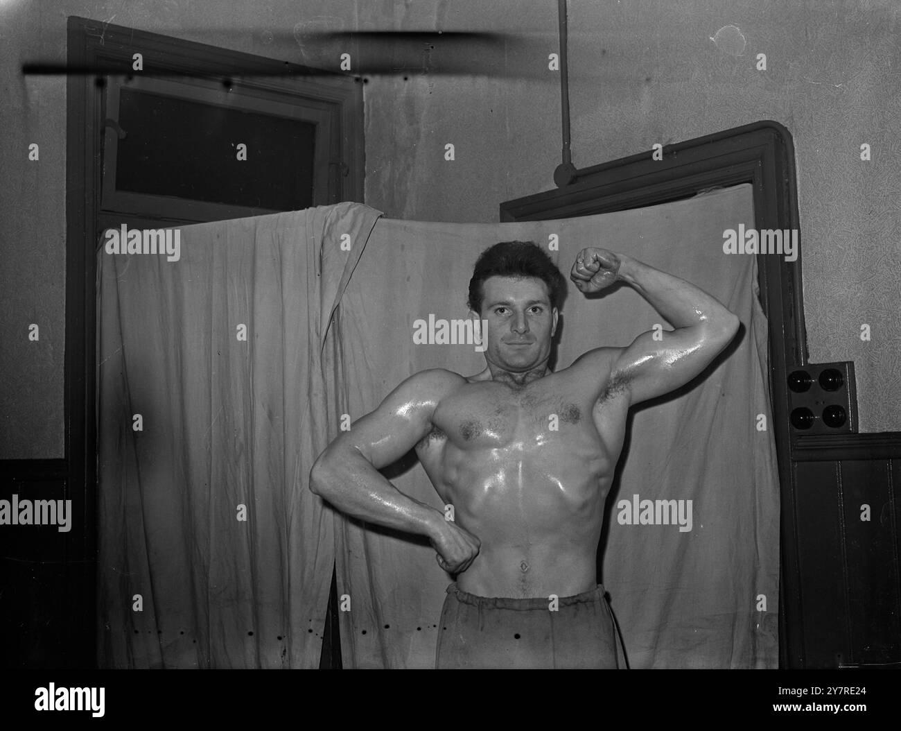 CHI SARÀ "MR LONDON”? 22.1,54. Il concorso Mr London per l'uomo più sviluppato del 1954 si svolgerà mercoledì prossimo presso il Municipio di Battersea. La competizione è gestita dal Body Sculpture Club. La foto di I.N.P. mostra Mick Sloane, 24 anni, scalpellino di 14 pietre e tre volte campione di sollevamento pesi delle Home Counties, visto in posa al goda Bar Bell Club, Tankerville Arms, Kennington, che spera di diventare Mr London 1954. Foto di notizie internazionali. Foto Stock