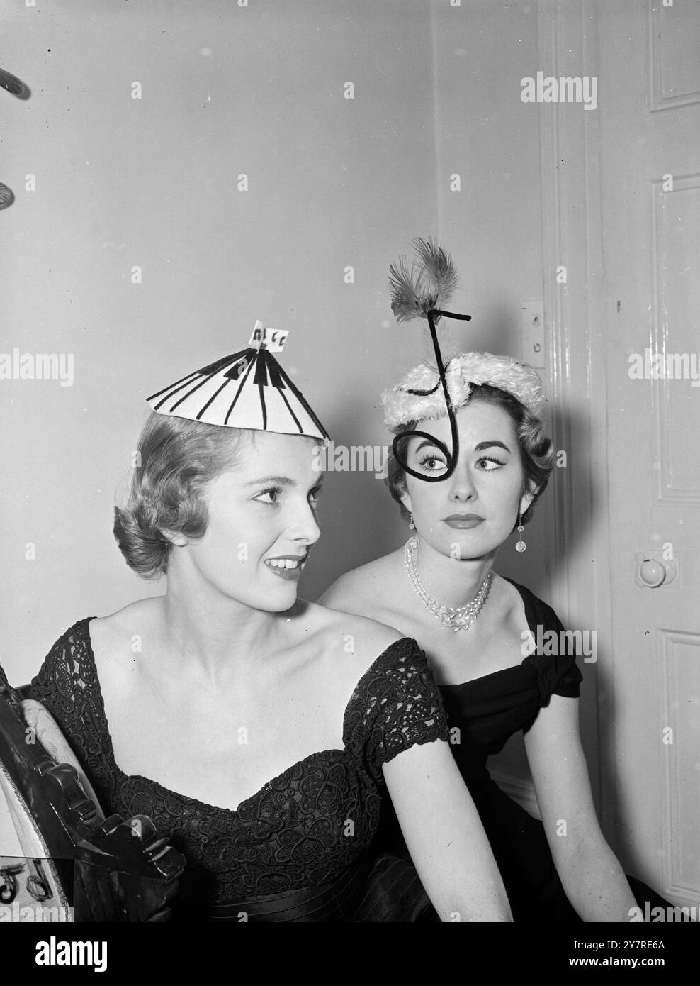 DENISE SALE SUL CARRO A NASTRO. 7,1.1954, due cappelli disegnati da Denise, Lady Newborough, ispirati al film 'Band Wagon' sono 'Band Wagon Keyboard' (a sinistra) indossato da Molly Frith, e il 'Band Wagon Eyecatcher' indossato da Gillian Tait. Immagine di Reg Palmer. PJ/73720 (2/19/20). Foto di notizie internazionali. Foto Stock