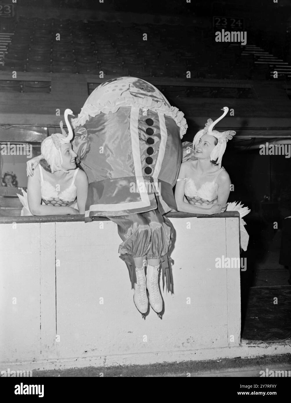 I cigni incontrano Humpty Dumpty 4.12.53. Trixie Moss (a sinistra) e Beryl Smith, vestiti da cigni, chiacchierano con Humpty Dumpty, Josie Morris, durante una prova per Humpty Dumpty on Ice a Wembley questa mattina. Foto di Joe Waldorf. PJ/73075 International News Photos. Foto Stock