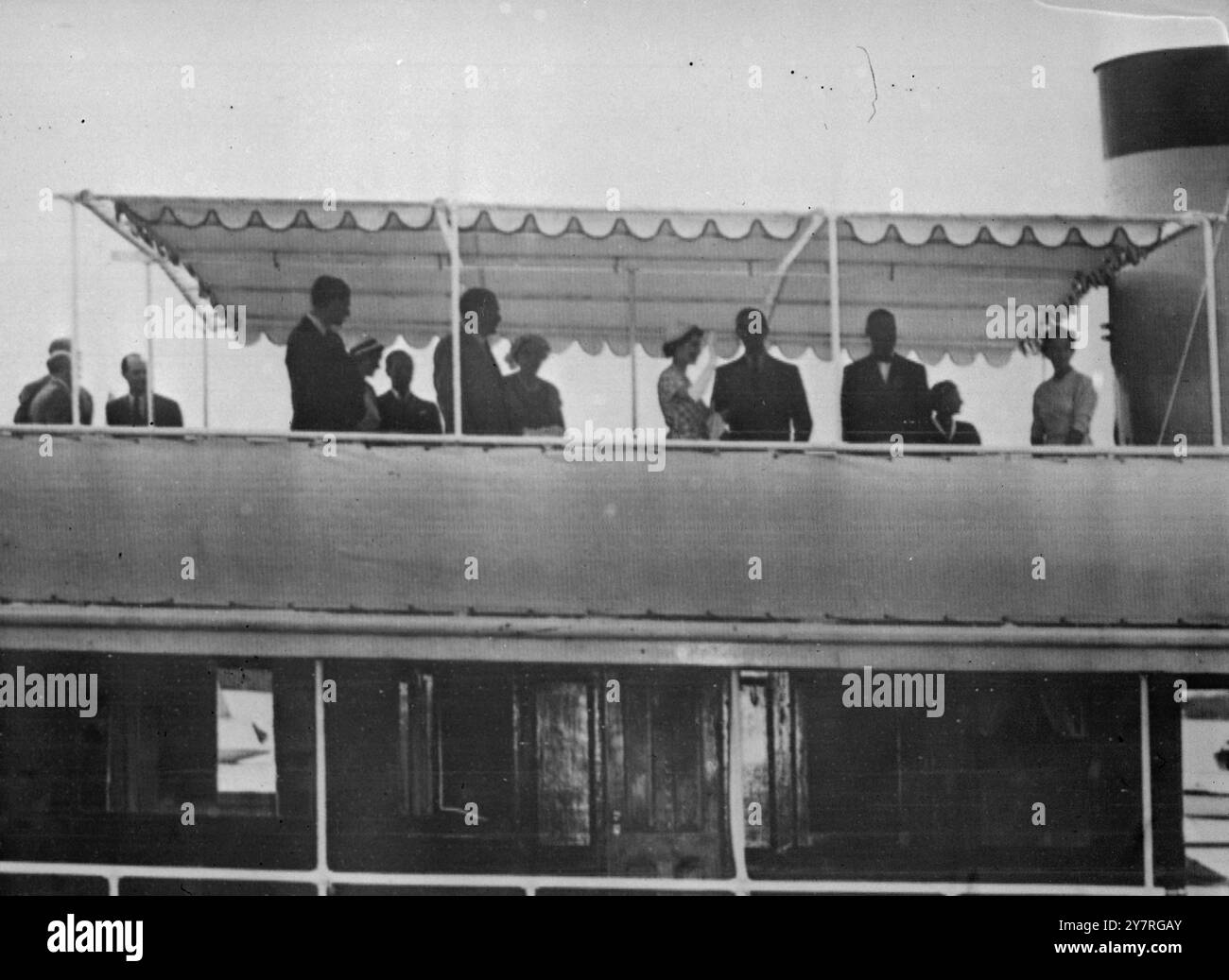 Immagine dalla radio. Kerryboat Queen and Duke Donia 25.11.53. Sunshine ha salutato la Regina e il Duca di Edimburgo quando hanno lasciato l'aereo di linea Canopus al loro arrivo alle Bermuda ieri pomeriggio. Folle di tifosi fiancheggiavano le strade della colonia decorate in modo allegro per accogliere il primo monarca britannico a visitarle. La foto mostra le onde della Regina mentre, insieme al Duca, si trova a bordo del traghetto Wilhelmina per un viaggio verso Somerset, all'estremità occidentale dell'isola. 1B/PJ/72818 foto di notizie internazionali. Immagine dalla radio. Costo: Quotidiani e serate £12 12s 0d, Provinciali £6 6s 0d. Foto Stock