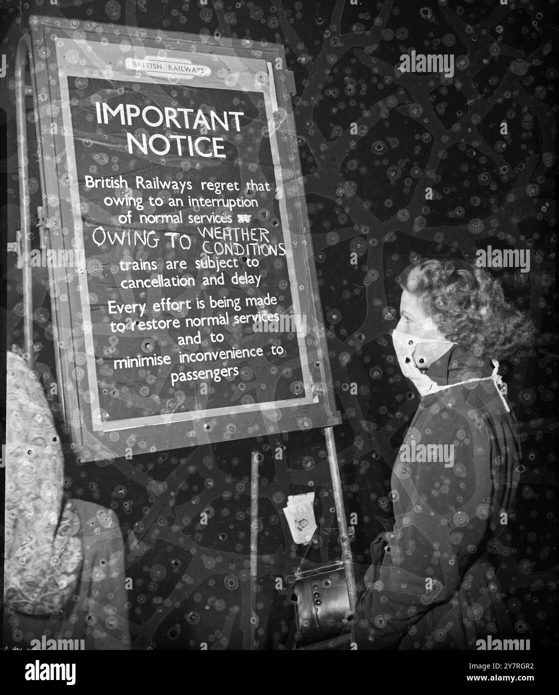 Lo smog avvolge Londra. Il 17.11.53, lo smog che oggi circondava Londra conteneva il traffico ferroviario, il trasporto e il traffico aereo. L'uso della maschera antismog era in pieno svolgimento per la prima volta. La foto di I.N.P. mostra una ragazza con una maschera di smog che legge l'avviso di nebbia a Charing Cross questa sera. Foto di Stuart Heydinger. EM/Hey/SPEC/72634,7 International New Photos. 359. Foto Stock