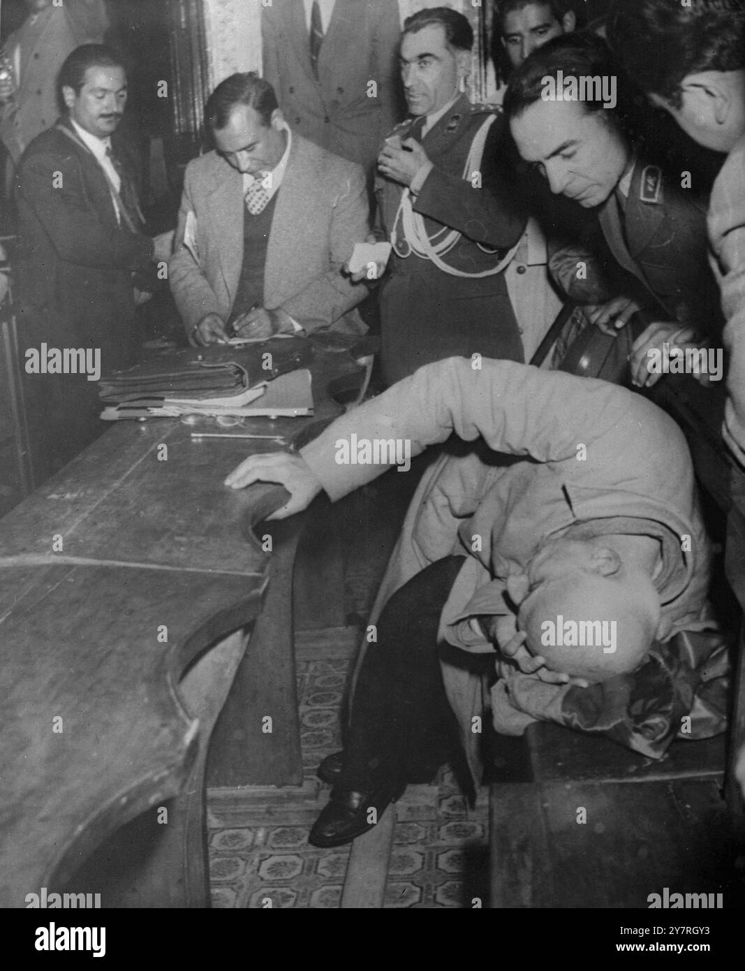 Mossadeq crolla in tribunale (foto dalla radio) 10.11.53. Un frenetico Dr. Mossadeq ha preso a pugni e maledetto il suo avvocato in tribunale oggi. L'ex Premier della Persia è sotto processo per la sua vita davanti a un tribunale militare. È accusato di sfidare lo scià e rovesciare il regime. Sobbalzante e urlante, il politico vestito di pigiama ha sferrato un duro colpo al suo avvocato e ha gridato: "Se parla, me ne andrò”. Poi scagliò da casa sua e cercò di uscire dalla sala degli specchi nella prigione di Sultanabad, dove è stato processato. Le foto di I.N.P. mostrano: Il dottor Mossadeq ha visto metà sdraiato sulla sua panchina in uno stato di exhau Foto Stock