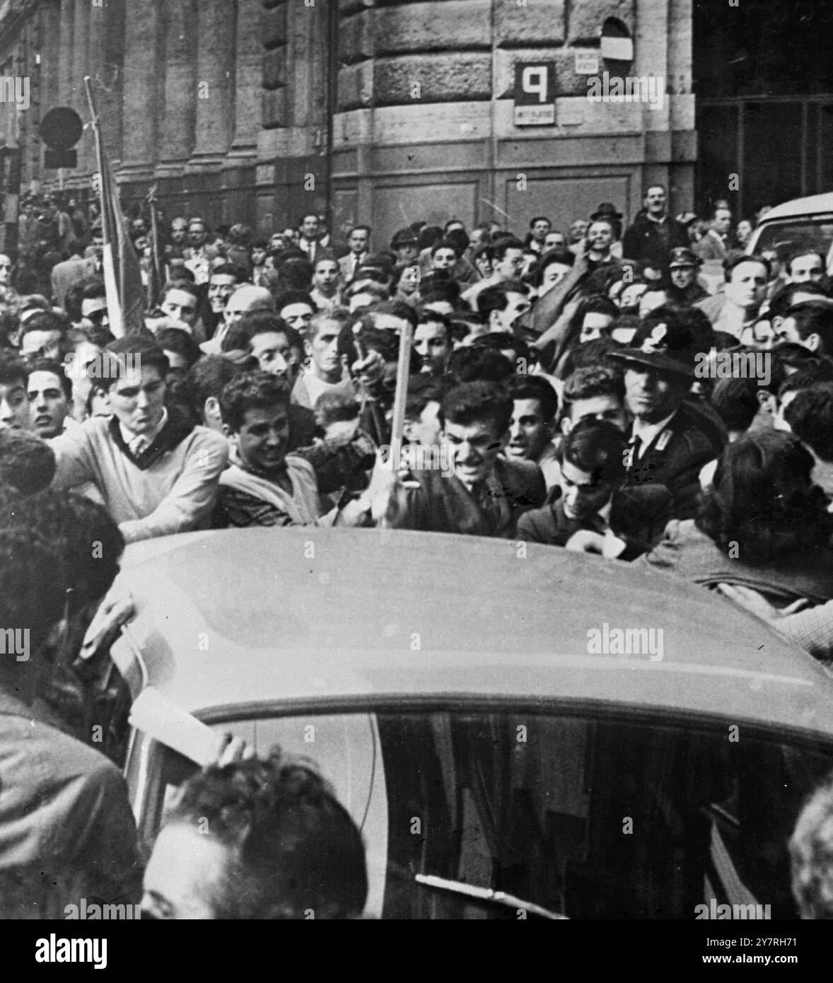 Gli studenti si ribellano a Roma. 6.11.53. (Foto dalla radio) a Roma e Milano sono scoppiate rivolte per protesta contro l'uccisione di due italiani nelle rivolte di Trieste di ieri. A Roma, la polizia ha sparato in aria per disperdere i manifestanti al di fuori dell'ambasciata degli Stati Uniti. La foto di I.N.P. mostra una folla arrabbiata che circonda un'auto jugoslava nelle rivolte di Roma di oggi. 3/EM/72419. Foto di notizie internazionali. Costo di riproduzione per i quotidiani di Londra £ 12,12,0. Provinciali £ 6,6,0. Foto Stock