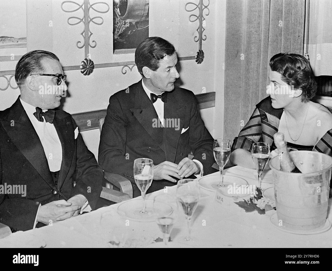 Asso dell'aria e paracadutista chiacchierano con la contessa. 4.11.53. Il capitano del gruppo Peter Townsend, addetto aereo all'ambasciata britannica a Bruxelles, è stato ospite di un ballo per agenti paracadutisti tenutosi sabato scorso. La foto di I.N.P. mostra due uomini con un interesse reciproco, il paracadutista colonnello Arissal (a sinistra) e il capitano dell'Asso aereo Townsend, trovano la conversazione della contessa di Liedekerke di interesse assorbente. 494/PJ/72347. Foto di notizie internazionali. Foto Stock