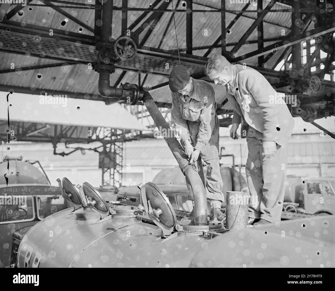 Il traffico di Londra diminuisce 24.10.53. Anche se gli uomini dei tre servizi hanno iniziato a fornire le forniture di benzina di Londra, i garage sono ancora chiusi e le strade stanno gradualmente diventando vuote di traffico man mano che sempre più veicoli si esauriscono. La foto di I.N.P. mostra un autista dell'esercito che riempie una petroliera con l'aiuto di un caposquadra di Shellmex al deposito principale di Fulham questa mattina. Foto di J. Waldorf. Foto di notizie internazionali. 70T26 II. Foto Stock