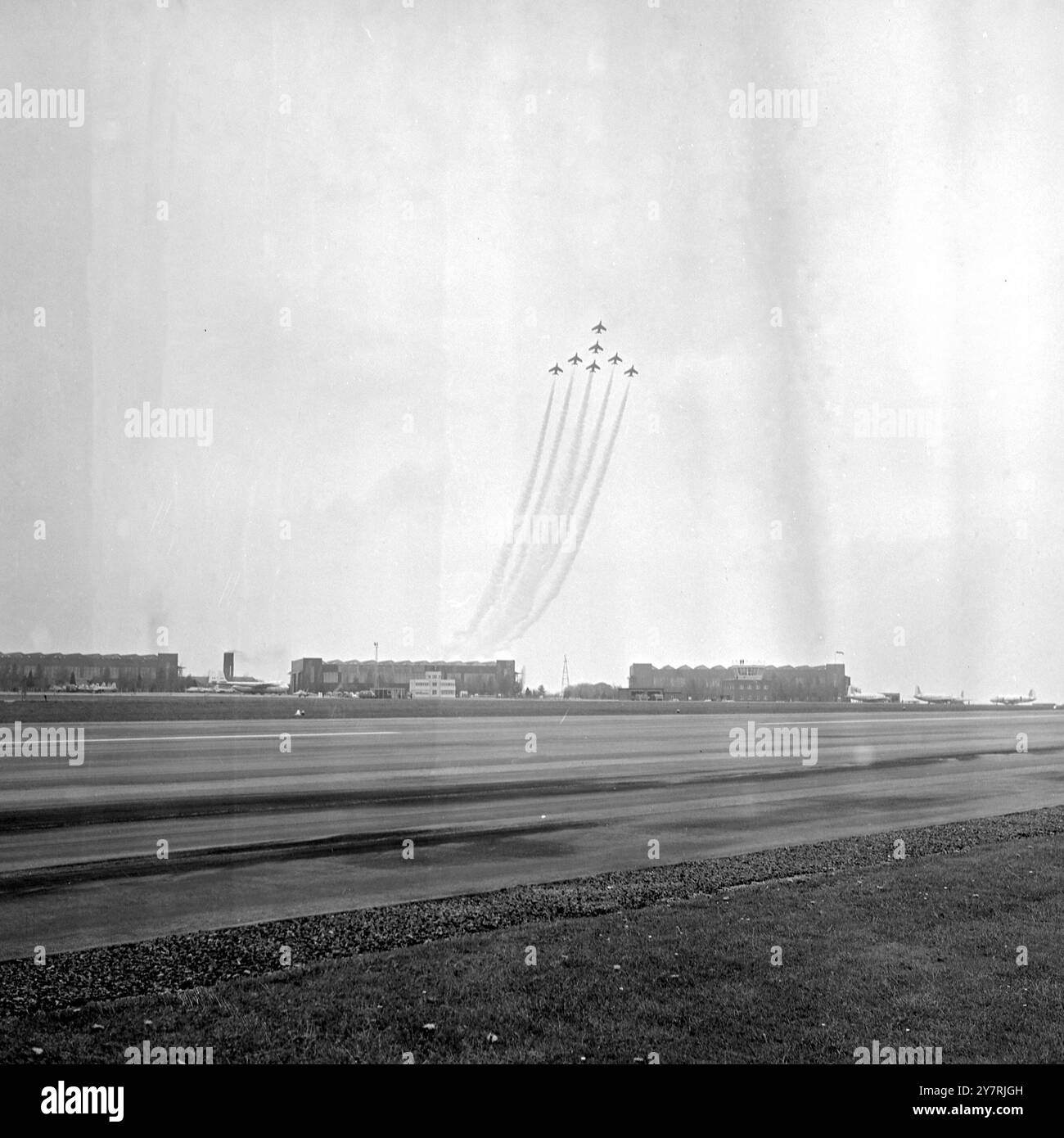 DIRETTAMENTE? Little Rissington, Gloucestershire, Inghilterra, Regno Unito : decollo verticale in formazione a mezzo cigno? Sembra certamente che la squadra di acrobazie della Royal Air Force Red Arrows, che ha dato la sua prima esposizione pubblica nel 1965 alla Little Rissington Central Flying School, stia ingrandendo quasi verticalmente. Anche se l'aereo decolla effettivamente in formazione, il team aveva appena completato un'immersione sopra l'aeroporto con i suoi getti Gnat dipinti di rosso a beneficio dei visitatori. Foto scattata il 6 maggio. 7 maggio 1965 Foto Stock