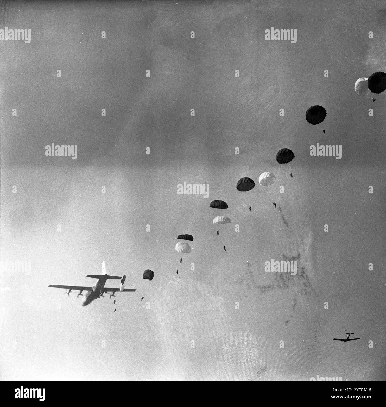 COLPIRE LA SILKRAF ABINGDON, BERKSHIRE, INGHILTERRA : Un processo contro paracadutisti della 16 Parachute Brigade, British Army, si infilarono dopo aver colpito la seta durante un lancio da un aereo da trasporto C-130 dell'USAF in corso prove congiunte di compatibilità tra la NATO britannica e quella americana qui. Le attrezzature e le truppe furono sganciate nella zona di Watchfield della RAF durante le prove, progettate per testare la cooperazione internazionale come stabilito dalla NATO in esercitazioni militari. 8 novembre 1965 Foto Stock