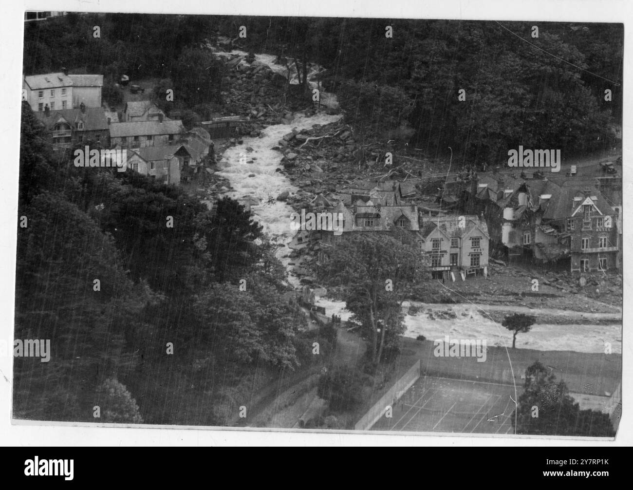 CITTÀ DEL DEVON LACERATA DA CASE SUL FIUME ALLAGATE SPAZZATE VIA. Lynton e Lynmouth, nel Devon settentrionale: Massi, macerie e rottami provenienti da edifici strappati gettano via il percorso (dal basso a sinistra alla parte superiore della foto) preso dal fiume Lyn, quando gonfiato dalle piogge torrenziali, cambiò rotta e infuriò attraverso la città di Lynmouth. Ponti, case, garage e altri edifici sono stati portati via e sette persone sono state segnalate scomparse dopo che il fiume ha cambiato rotta tra le città gemelle di Lynton e Lynmouth. Scene di inondazioni sono state ineguagliabili nella storia del West Country a seguito delle grandi tempeste che si susseguono Foto Stock