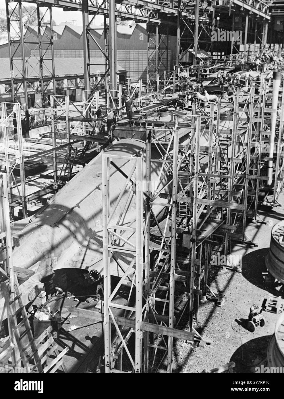PRIME FOTO ESCLUSIVE DEL PRIMO SOTTOMARINO ATOMICO. (LO SCAFO DEL PRIMO A-SUB AL MONDO SI AVVICINA AL COMPLETAMENTO). CONN. GROTON. Questa vista generale della USS NAUTILUS, in costruzione, è una delle prime immagini del primo sottomarino a propulsione atomica al mondo, realizzato da International News Photos, all'interno del cantiere della divisione Electric Boat della General Dynamics Corporation a Groton. Lo scafo dell'A-Sub è racchiuso in un ponteggio. È lungo circa un isolato cittadino con uno spostamento stimato di 3.000 tonnellate. Il Nautilus dovrebbe essere pronto per il servizio il prossimo anno. L'imbarcazione avrà molti vantaggi rispetto al Foto Stock