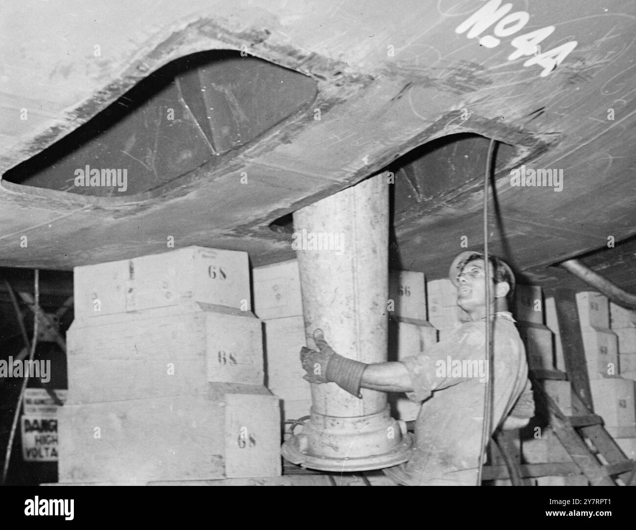 PRIME FOTO ESCLUSIVE DEL PRIMO SOTTOMARINO ATOMICO. (NELLA PANCIA DEL SOTTOMARINO ATOMICO). Groton, Conn queste prime foto di primo piano del primo sottomarino atomico al mondo sono state scattate da International News Photos all'interno del cortile della divisione Electric Boat della General Dynamics Corporation e sono state cancellate dal Dipartimento della difesa. L'enorme velivolo, alimentato da motori atomici, dovrebbe essere pronto per l'uso il prossimo anno. Ecco una vista ravvicinata di un tubo che viene sollevato nella pancia del sottomarino attraverso una delle bocchette. Quando il Nautilus, come viene chiamato, sarà completato, saranno i larghi Foto Stock