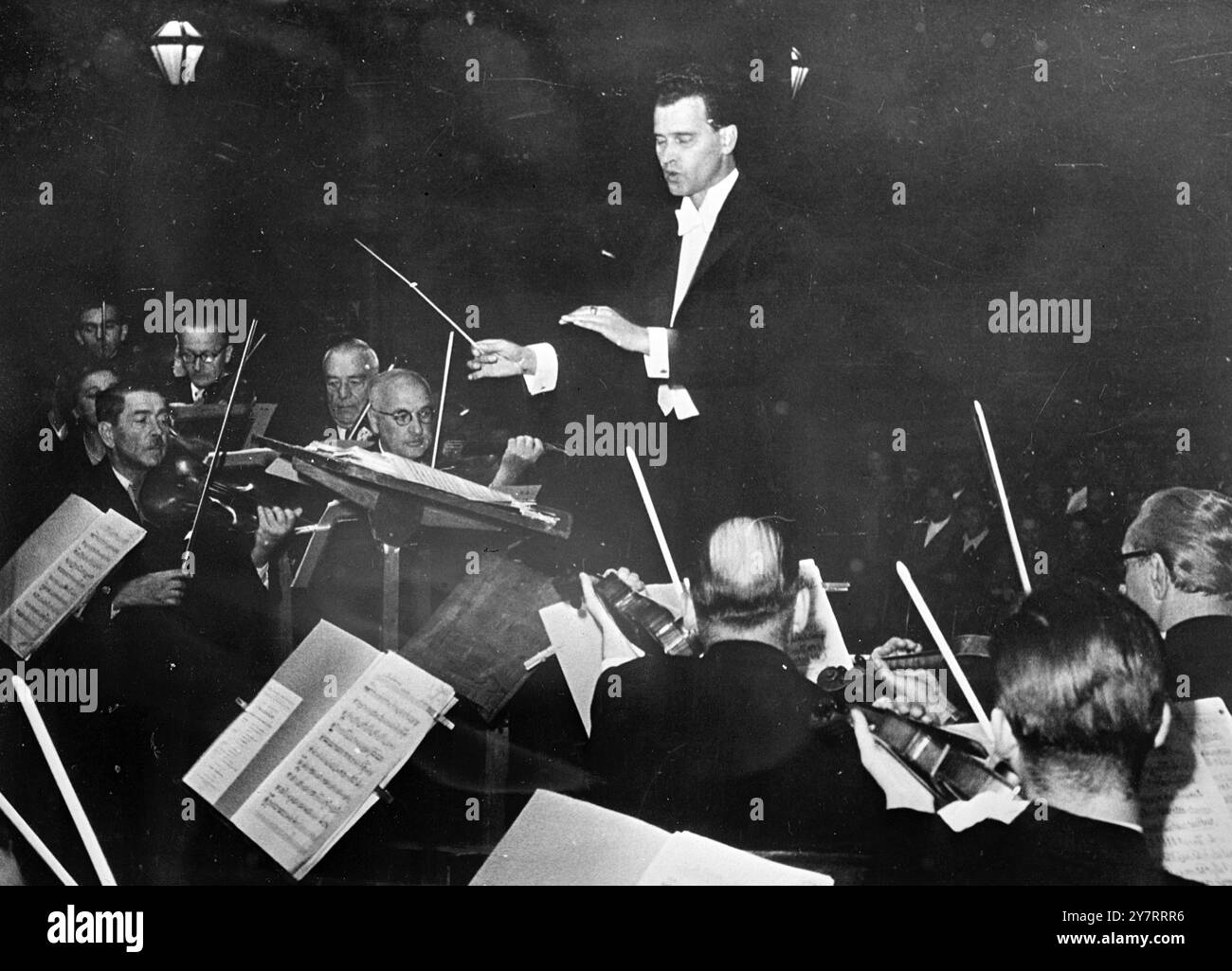 Un NUOVO STRAUSS DIRIGE WALTZ A VIENNA 6,8.53A il nuovo Strauss, Eduard - pronipote dell'immortale Johann, ha fatto una prima apparizione pubblica a Vienna questa settimana per dirigere un'orchestra da concerto nell'esecuzione di un nuovo valzer scritto da lui stesso. Un pubblico numeroso ha acclamato il valzer come degno della città e del nome del suo compositore. La foto mostra Eduard Strauss che dirige il suo valzer nel cortile del municipio di Vienna. 6 agosto 1953 Foto Stock