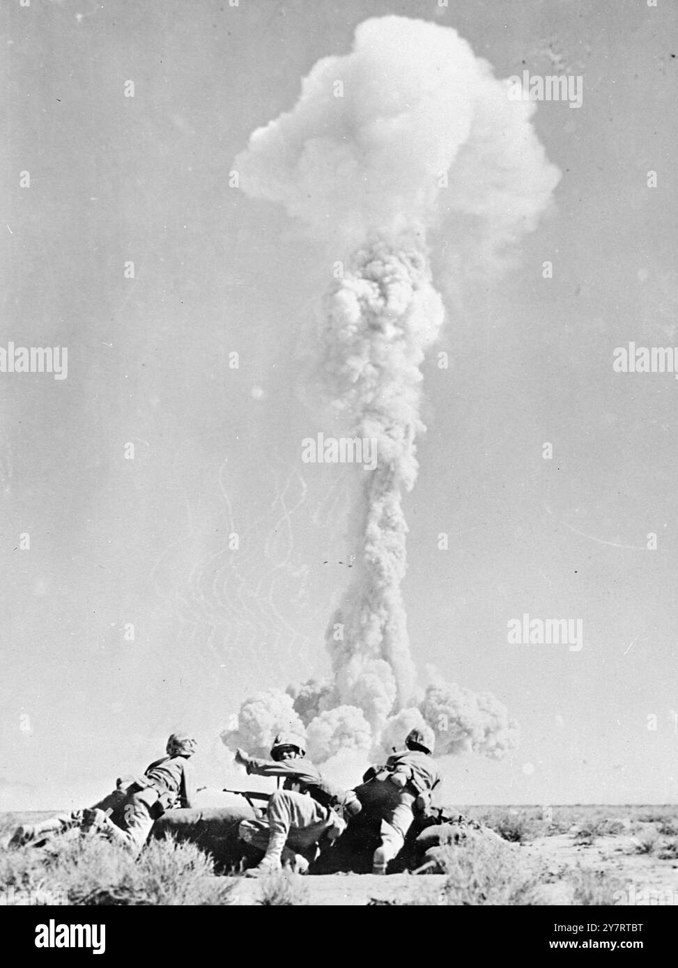TEST DI ESPLOSIONE ATOMICA. Las Vagas, Nevada...... Il fungo atomico prende forma mentre i Marines si preparano a caricare. La brillante palla di fuoco arancione che segna la 17° esplosione atomica continentale della Nazione e' scoppiata in basso sopra i campi di test atomici degli appartamenti Yucca il 1° maggio, mentre le pelli marine accoccolate nelle foglioline nelle vicinanze. La bomba è stata sganciata da un aereo basso da circa 1500 piedi. Il brillante flash che ne deriva durò molto più a lungo rispetto alle precedenti palle di fuoco e la sporcizia che fu immediatamente sollevata in aria seguì dietro la familiare nuvola di funghi a causa della mancanza di aria curre Foto Stock