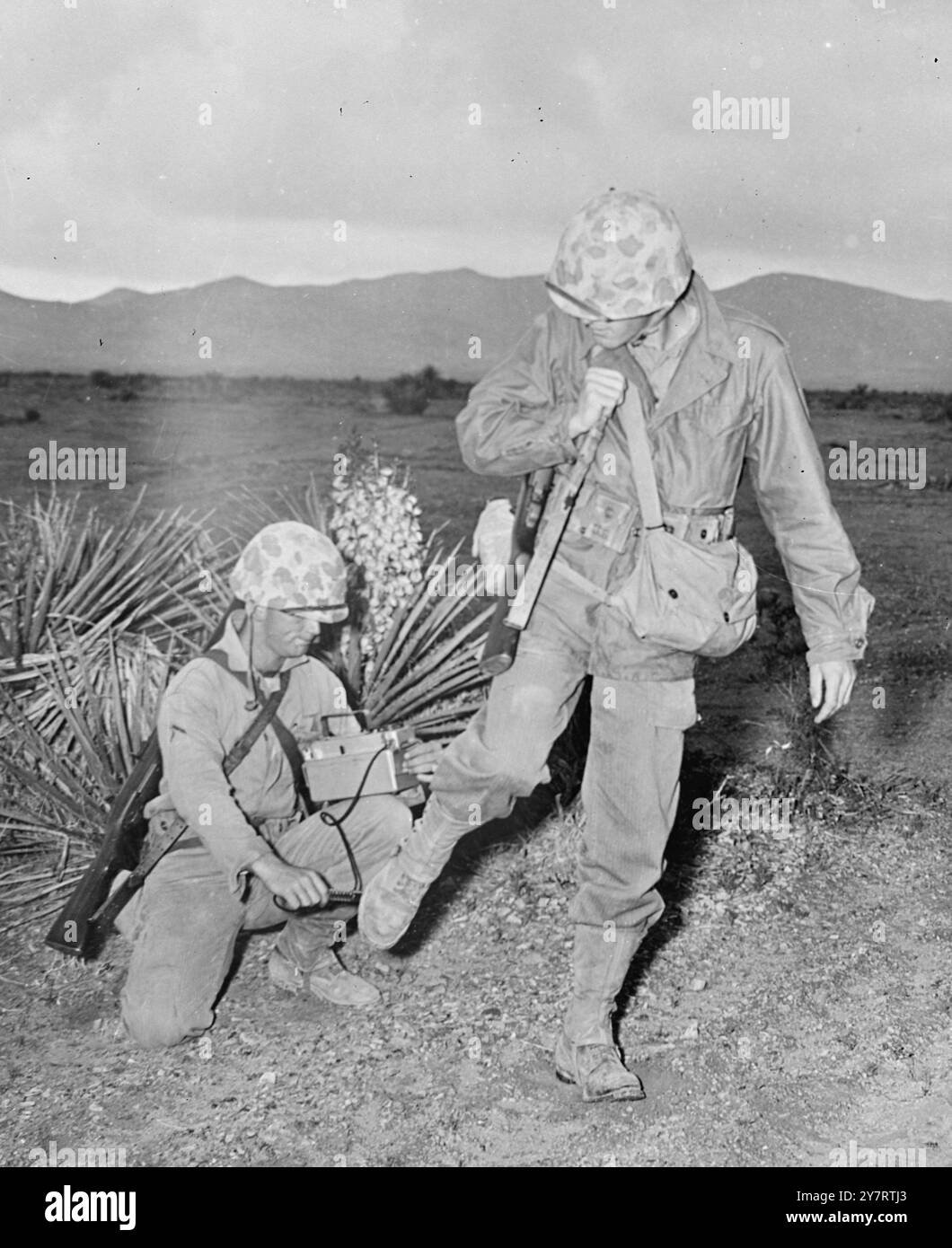 Un Marine monitora un collega Leatherneck per la radioattività dopo che i Marines hanno esaminato l'area di esplosione in avanti del recente test di bomba atomica presso l'AEC Nevada Proving Grounds, Nevada, USA.24 aprile 1952 Foto Stock