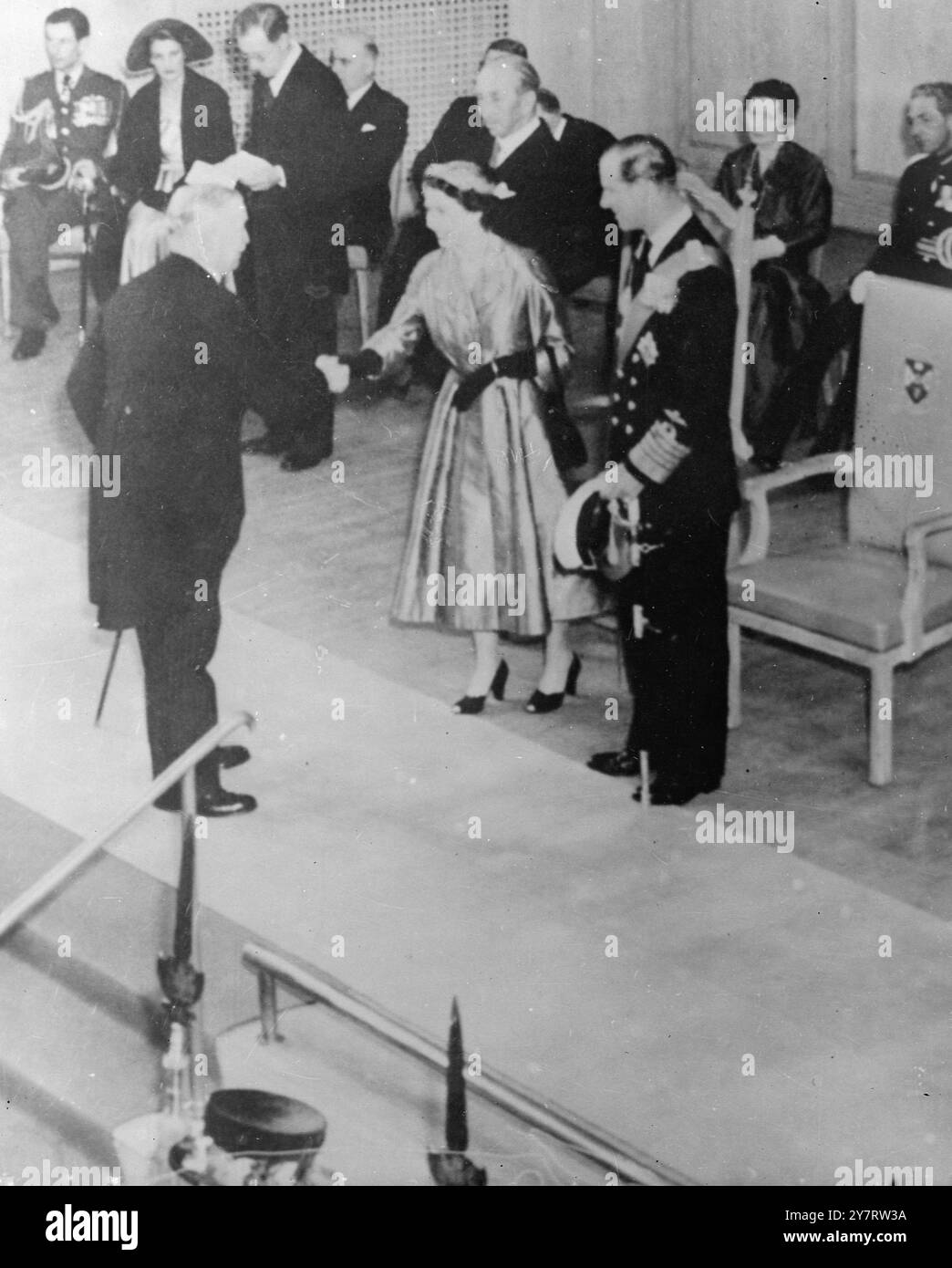 REGINA ALLA WHITLA HALL. 2,7.53. La regina, in piedi con il duca di Edimburgo, ricevendo ospiti quando frequentò la Whitla Hall di Belfast per ricevere indirizzi fedeli. Subito dietro la regina c'è il visconte Brookeborough, primo ministro dell'Irlanda del Nord. Nell'angolo in alto a sinistra c'è il capitano del gruppo Peter Townsend, un intimo amico della famiglia reale. Quando questa foto è stata scattata, c'è stata un'esplosione che si ritiene sia stata causata da una bomba dell'esercito repubblicano irlandese, che ha danneggiato un ponte ferroviario vicino al confine tra l'Eire e l'Irlanda del Nord oggi. 2 luglio 1953 Foto Stock