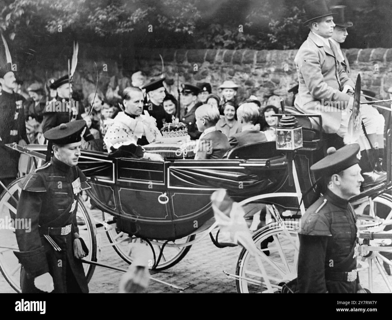 LA CORONA DI SCOZIA VIENE PORTATA A ST. GILES 25.6,53. La Corona, lo scettro e la Spada di Stato, gli antichi regalis conosciuti come le onorificenze di Scozia, sono stati portati davanti a H.M. la Regina quando ha partecipato al servizio nazionale di ringraziamento e dedizione nella Cattedrale di St. Giles, Edimburgo, ieri. Le foto mostrano con una scorta di un ufficiale e dieci arcieri, le Honours of Scotland sono trasportate sulla carrozza che precede quella della Regina. Il Duca di Hamilton può essere visto portare la Corona di Scozia. 25 giugno 1953 Foto Stock