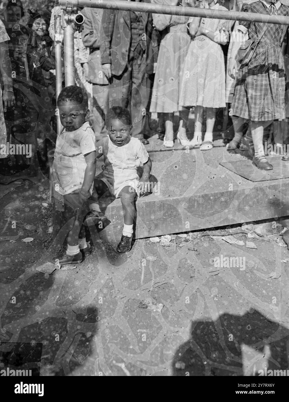 CHE PROBLEMA C'È? ...? 24.5,53. Migliaia di persone si fermano sul percorso della processione dell'incoronazione per vedere le decorazioni colorate che vengono erette. SPETTACOLI FOTOGRAFICI: Due piccoli ragazzi si riposano dalla passeggiata nel centro commerciale. I fratelli Ward Patrick (2) e Charles (3). Il loro padre è di Trinidad.24 maggio 1953 Foto Stock