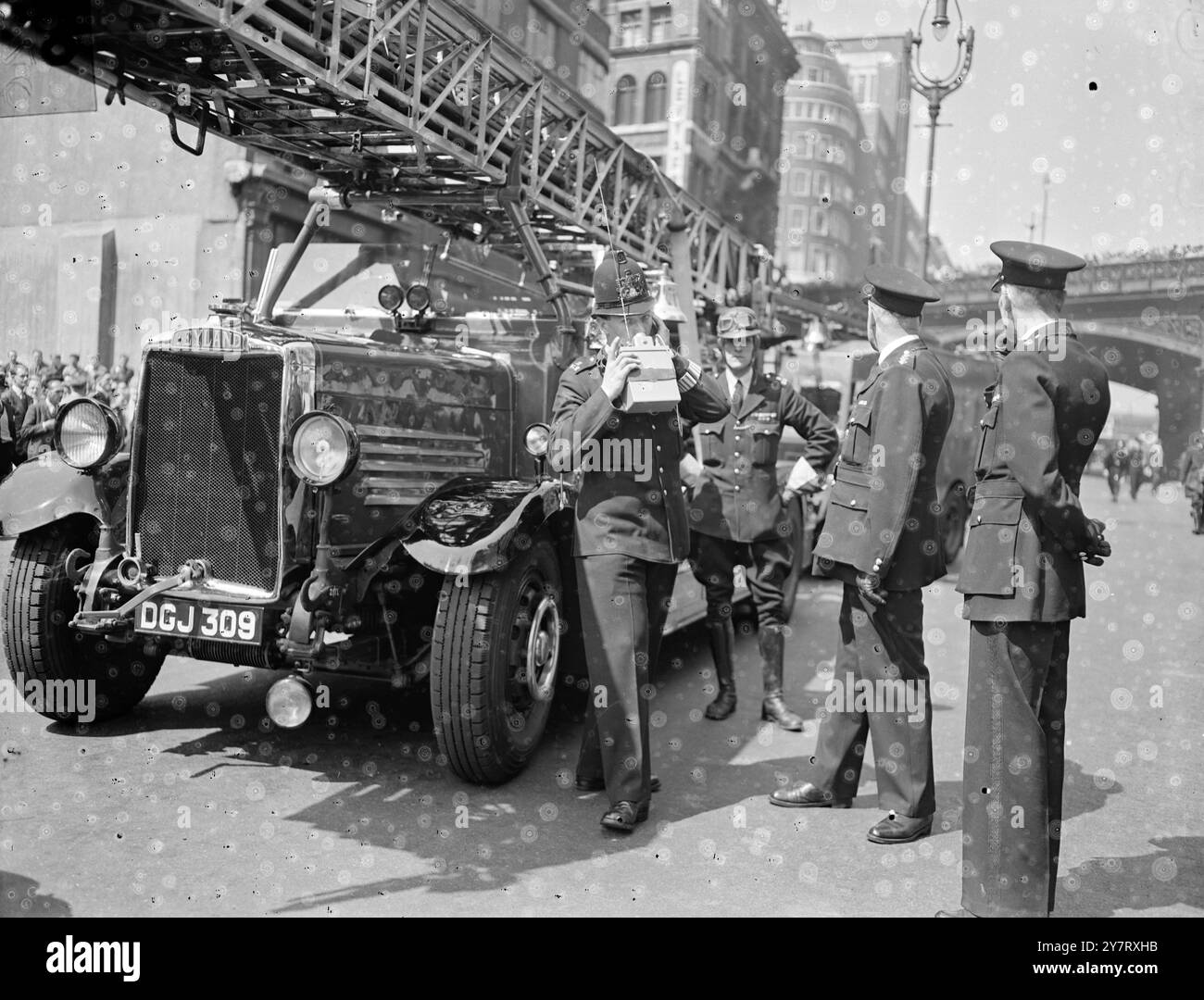 LA FOLLA DELL'ORA DI PRANZO GUARDA i lavoratori DELLA FIREOffice che fanno la pausa pranzo, guardano i pompieri che affrontano un incendio scoppiato in un edificio di Farringdon Street, Londra, Inghilterra. Spettacoli fotografici : la polizia utilizza radio walkie-talkie sulla scena dell'incendio. 11 maggio 1953 Foto Stock