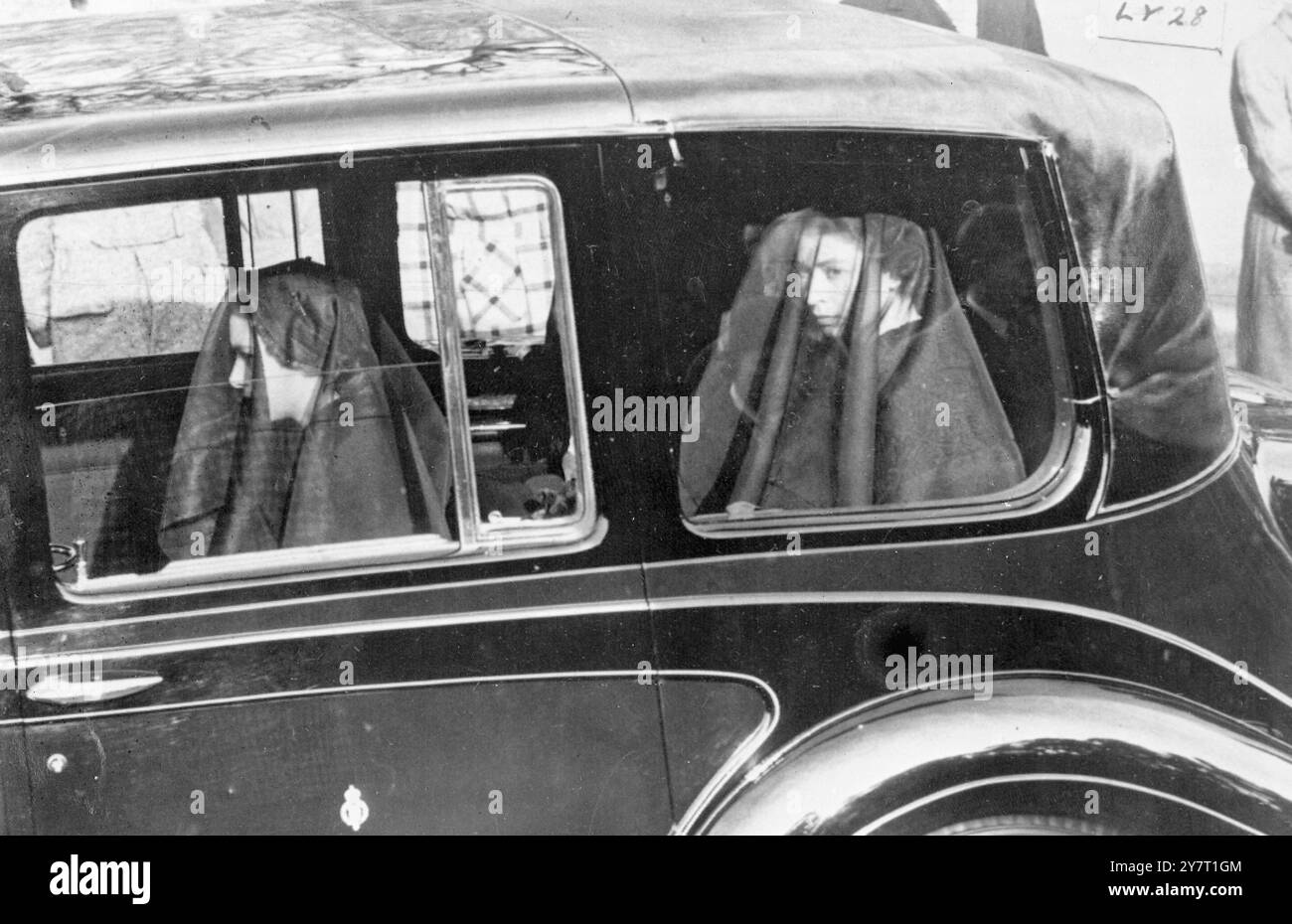 QUEEN AND PRINCESS IN SANDRINGHAM PROCESSIONE FUNEBRE DI RE GIORGIO vi 12-2-52 FOTO MOSTRA:- la principessa Margherita (a sinistra) e la regina Elisabetta II indossando i loro veli lutto mentre cavalcavano nella processione funebre da Sandringham alla stazione di Wolferton, oggi: Il King's Coffin è stato portato da Wolferton in treno a Londra.12 febbraio 1952 Foto Stock