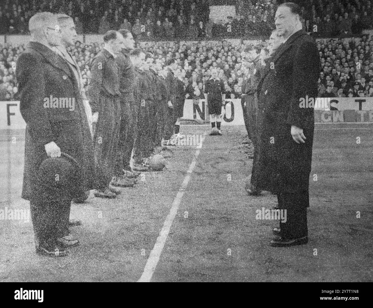 LA FOLLA SPORTIVA DEL SABATO RENDE OMAGGIO AL LORO RE 9-2-52 Rattles e campane che di solito fanno un rumore come i tifosi tifo per le loro squadre durante la partita di calcio del sabato pomeriggio in Inghilterra, sono rimasti in silenzio oggi, mentre la folla e i giocatori si sono tutti alzati per un minuto in un sentito omaggio al defunto re George VL. Poi la folla ha cantato l'inno preferito del re 'attenersi con LE FOTO DI Meth I.N.P.:- le due squadre, Tottenham, (a sinistra) e Arsenal (a destra) con i suoi funzionari rendono omaggio in un minuto di silenzio prima della partita di Tottenham, a Londra, di oggi. Foto di J. Pavies. NOTIZIE INTERNAZIONALI PHOT Foto Stock