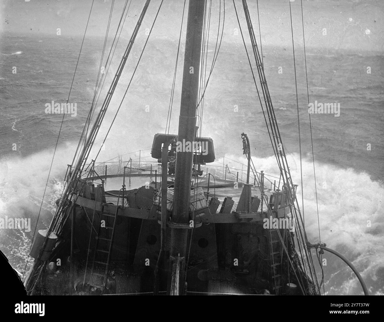 CONVOGLIO INVERNALE queste foto sono state scattate a bordo di una nave di scorta che ha accompagnato un convoglio che portava cibo dal mondo esterno e rifornimenti da porto a porto attraverso i mari invernali resi pericolosi dalle mine e dai sottomarini, i cieli in testa una costante minaccia da parte degli aerei da guerra tedeschi. Il tempo era brutto. Lo spray si è bloccato sui vestiti e sui volti dei pistoleri e degli uomini che stavano a guardare. I mari pesanti battono contro queste piccole navi. Hanno portato il loro carico. La foto mostra: Una carica di profondità caricata con cautela a poppa. 23 dicembre 1940 Foto Stock