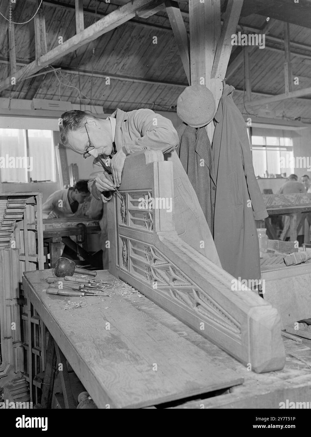 ARTIGIANI NELLA '' HOUSE'' alcuni dei migliori artigiani britannici sono ora al lavoro nella realizzazione di lavori in legno per la nuova camera dei comuni. La quercia inglese che si trova nelle foreste dello Shropshire e dell' Herefordshire da circa 300 anni , viene utilizzata in questo importante compito . La vecchia camera è stata bruciata durante il blitz durante la guerra , e la nuova dovrebbe essere pronta per l' occupazione subito dopo la pausa estiva del 1950 . IMMAGINI:- Craftsman A.W. PATTENDEN , di Wealdstone ( Middx) , che lavora su una parte della sedia del sergente - at - Arms alla camera dei comuni durante la guerra Mr . Foto Stock