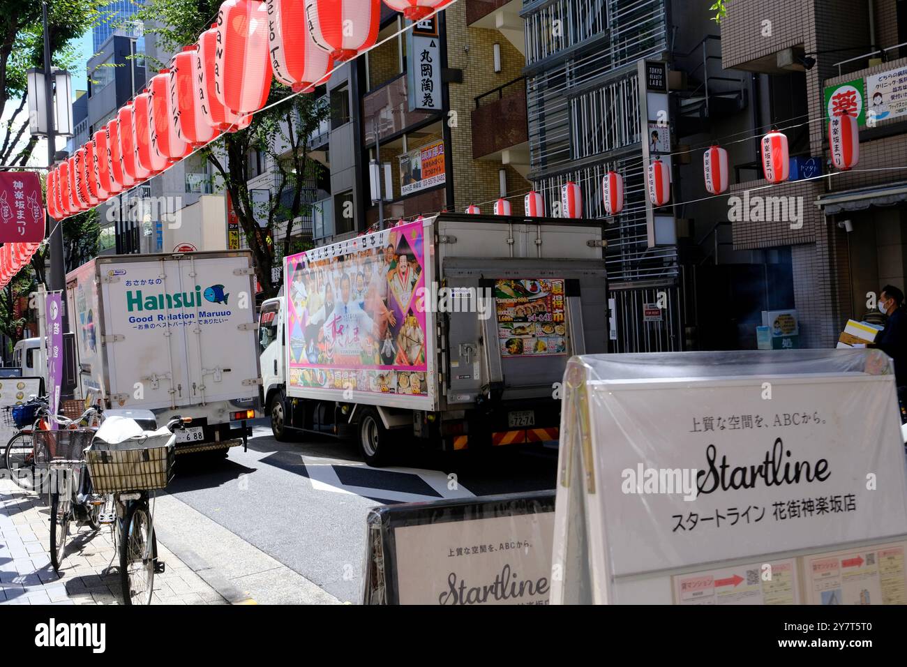 Camion commerciali che scaricano buoni per i negozi su Kagurazaka-dori, la principale strada dello shopping nel quartiere di Kagurazaka decorata con lanterne rosse. Shinjuku, Tokyo, Giappone Foto Stock