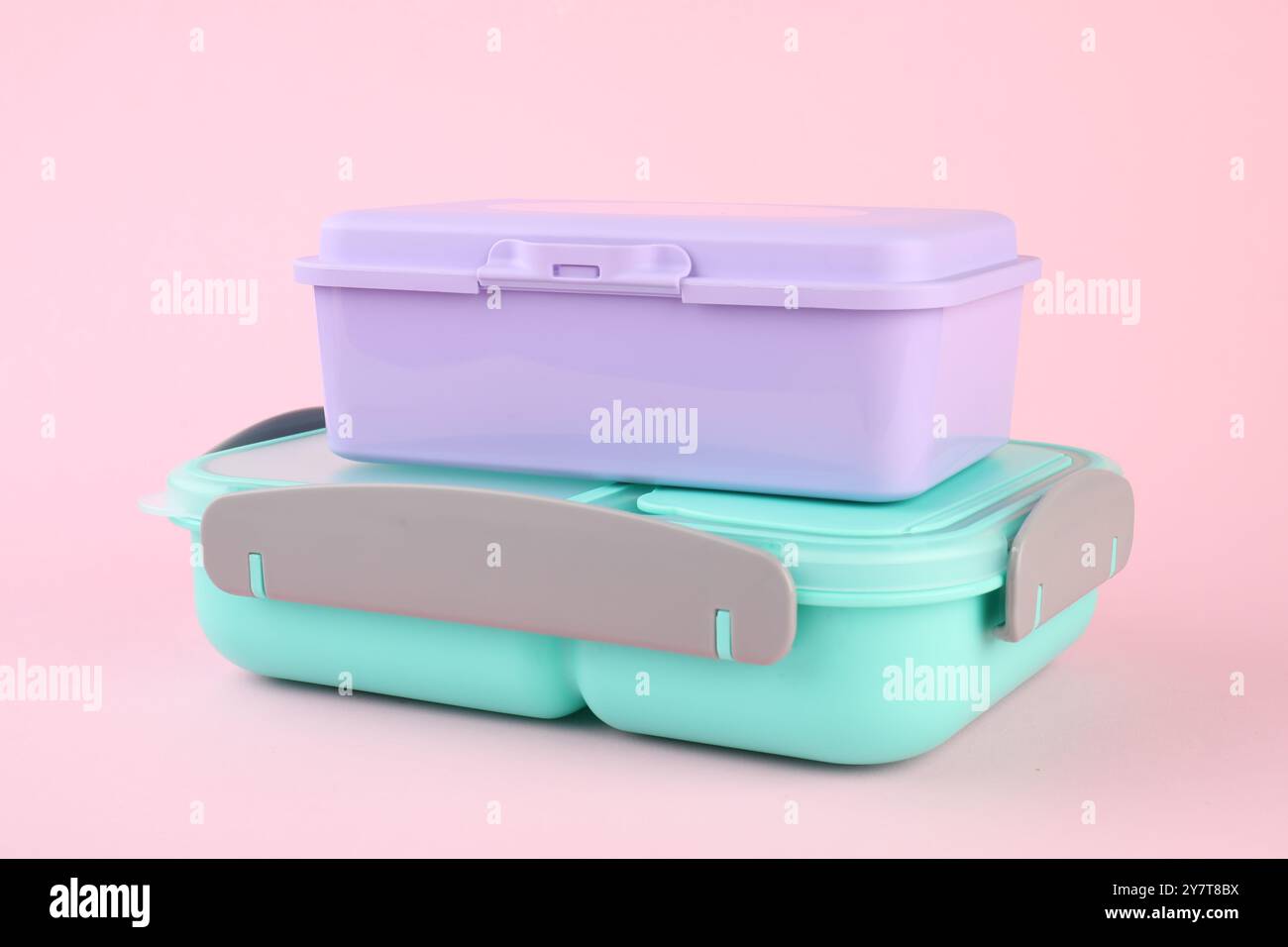 Due portavivande in plastica su sfondo rosa chiaro Foto Stock