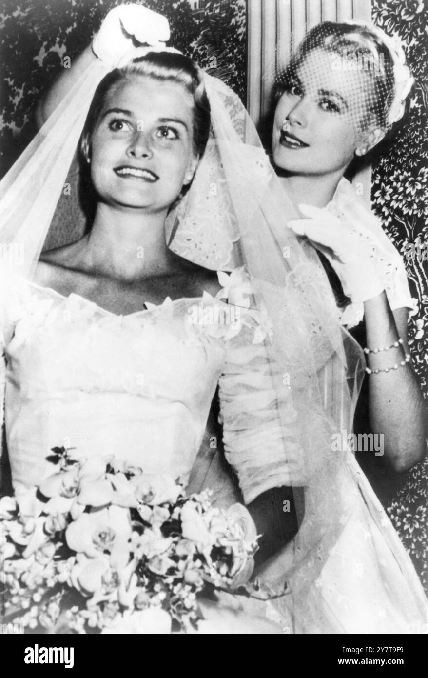 GRACE KELLY NEL RUOLO DI SUPPORTO AL MATRIMONIO DI SUA SORELLA la vincitrice dell'Oscar Grace Kelly ha partecipato al matrimonio di sua sorella come Maid of Honour, quando sua sorella Elizabeth ha sposato Donald Caldwell Levine di Pittsburgh. Il matrimonio si è svolto alla St Bridgets Church di Filadelfia sabato 27 giugno. Spettacoli fotografici : Grace Kelly , Maid of Honour al matrimonio di sua sorella fissa il velo delle spose prima di entrare nella chiesa. 27 giugno 1955 Foto Stock
