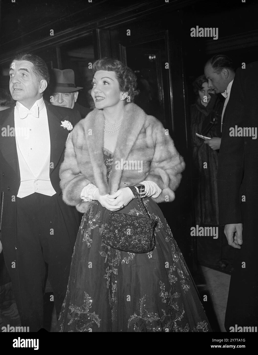 CLAUDETTE RISPLENDE AL ROYAL FILM SHOW un abito splendidamente ricamato, con borsetta abbinata e pellicce tagliate vengono indossate dalla piccante attrice hollywoodiana Claudette Colbert mentre arriva all'Empire, Leicester Square, Londra, per la Royal Film Performance Tonight. Claudette era una delle star inglesi e americane che apparivano nello spettacolo. Il re, la regina e altri membri della famiglia reale stavano assistendo alla piena esecuzione, data in aiuto del Cinematograph Trade Benevolent Fund. 31 ottobre 1950 Foto Stock
