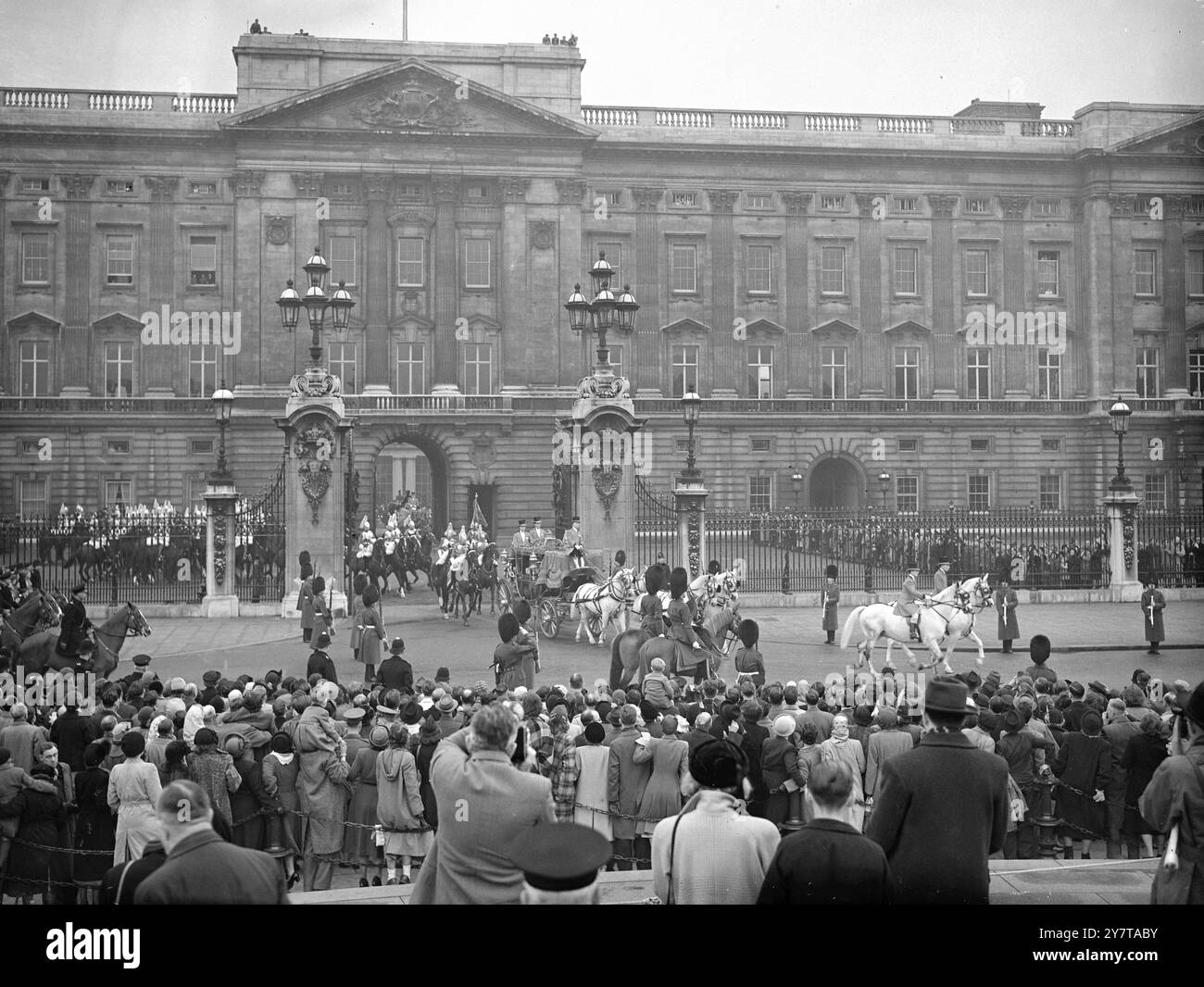 IL RE E LA REGINA GUIDANO VERSO L'APERTURA DEL PARLAMENTO il re, accompagnato dalla regina, guidando nello stato da Buckingham Palace a Westminster (Londra), martedì, per l'apertura del Parlamento. Le loro Majestie cavalcarono nell'allenatore dello Stato irlandese con una scorta del sovrano composta da quattro divisioni della cavalleria domestica. Il percorso della processione era fiancheggiato dalle truppe della Brigata delle guardie. SPETTACOLI FOTOGRAFICI: La folla che guarda la processione reale lascia Buckingham Palace per dirigersi oggi al Parlamento. 31 ottobre 1950 Foto Stock
