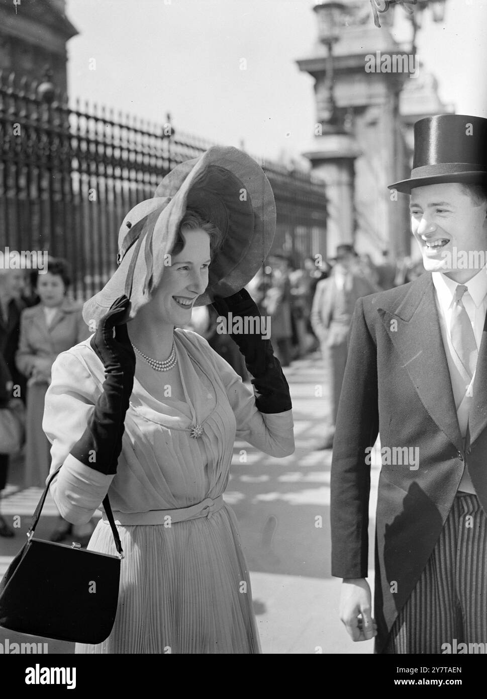 ASSICURANDOSI IL SUO CAPPELLO DA FESTA AL PALAZZO 10 maggio 1950 la signora Dermot De Trafford si regge sul suo grande cappello in una raffica di vento mentre arriva a Buckingham Palace, Londra, oggi (mercoledì) per il Presentation Party - secondo della presente serie - dato dal Re e dalla Regina. Foto Stock