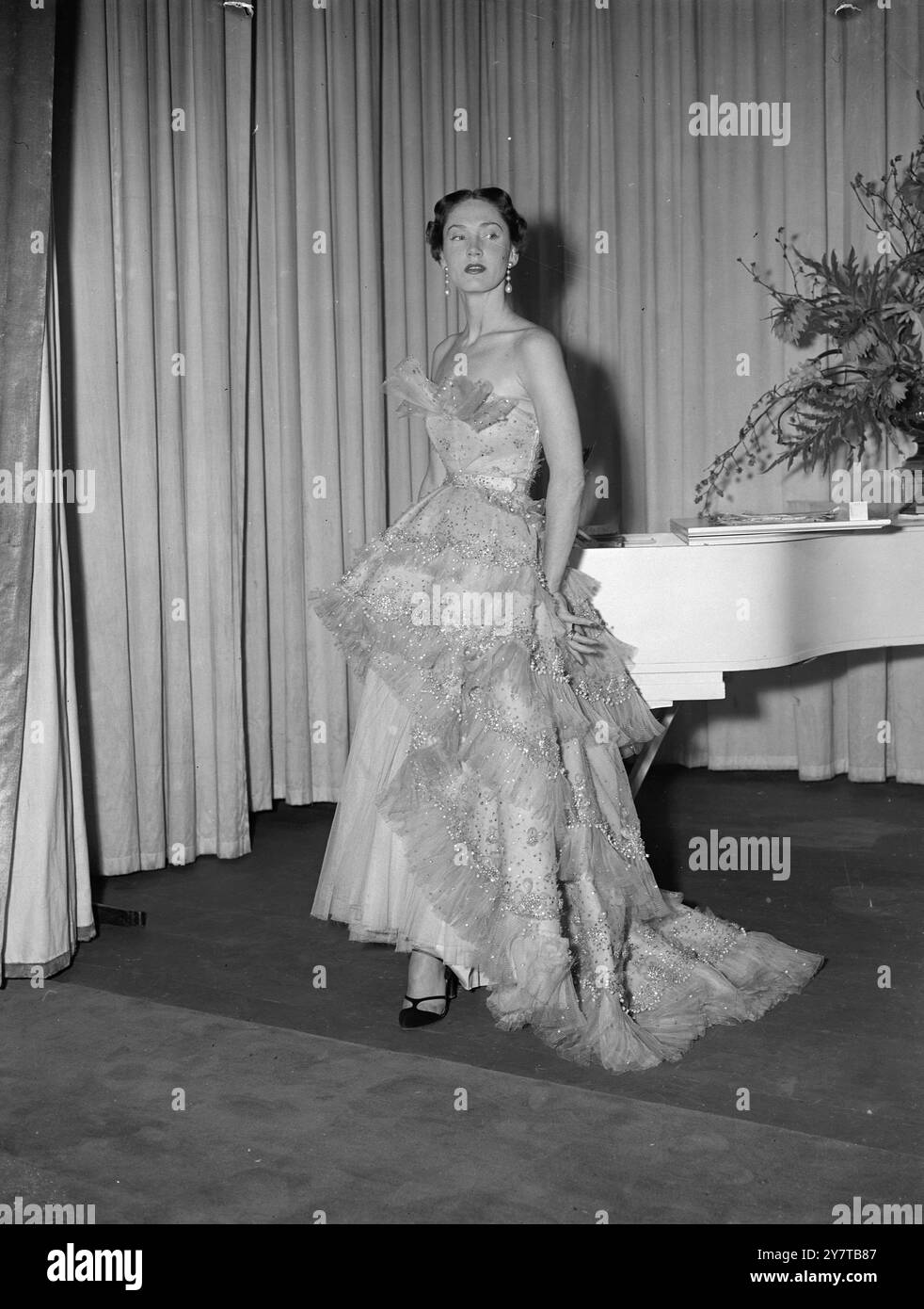 MOZART AL SAVOY 25 aprile 1950 le modelle di Parigi hanno i riflettori sulla moda a Londra mentre il famoso stilista francese Christian Dior presenta la sua collezione estiva in due sfilate di moda al Savoy Hotel oggi (martedì). Questa è la sua prima mostra a Londra. Dior ha volato con i suoi manichini da Parigi per l'occasione. Tutte le mode sono in tessuti britannici. Cinquecento persone pagano due sterline e due scellini ciascuno per vedere gli stili, e il ricavato è per aiutare a finanziare un Museo del Costume a Londra. Spettacoli fotografici: Un abito Dior intitolato Mozart, l'abito più costoso della sfilata di moda di Parigi Foto Stock