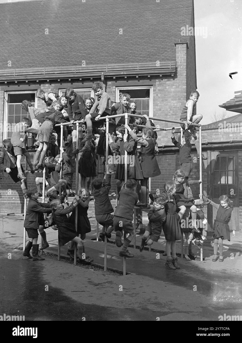 35 BAMBINI NELLA " PALESTRA DELLA GIUNGLA " la risposta a quei stimolanti parchi giochi di cui i bambini si lamentano, questa costruzione a gabbia tubolare, la " palestra della giungla " fotografata mentre era sotto attacco da 35 bambini della scuola elementare Graiseley di Wolverhampton. Idea della struttura : per dare ai bambini il massimo del divertimento e dell'esercizio fisico nello spazio limitato. 21 marzo 1950 Foto Stock