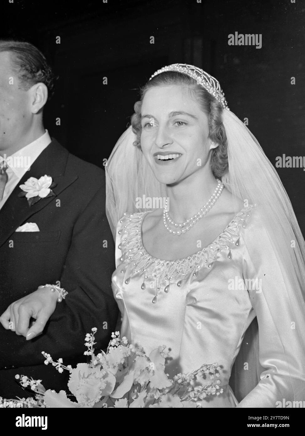 LA SPOSA GIOIELLATA Miss Solna Marianne Anita Joel , figlia maggiore del signor e della signora Stanhope Joel di Lyphurst , Cranleigh, Surrey, e nipote della defunta Solly Joel, il milionario di diamanti, sposò il signor Harry Thompson Jones, unico figlio del tenente colonnello e della signora Victor Jones di luggershill, Broadway, Worcestershire, oggi nella St Peter's Church, Eaton Square, Londra. La signorina Joel e' un'abile cavaliere. L'IMMAGINE MOSTRA:- la sposa, nel suo abito di raso di avorio, che parte dopo il matrimonio. Lo scollo dell'abito è ricamato in perle di semi e strass. 14 marzo 1950 Foto Stock
