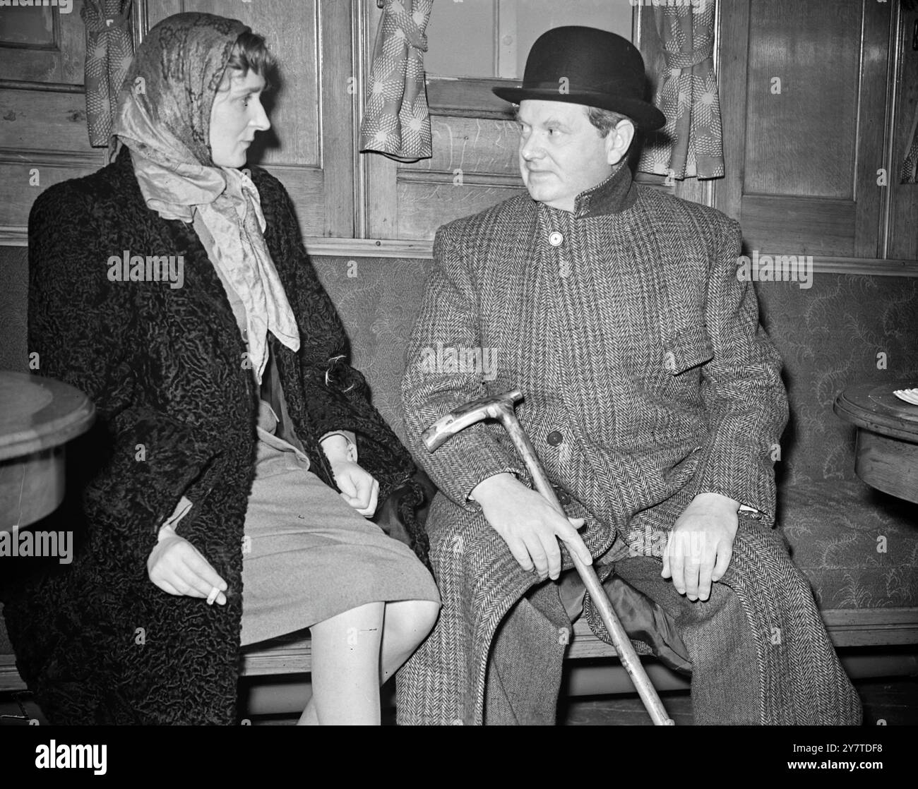 EVELYN WAUGH CASA dell'autore Evelyn Waugh , soffocato nel suo cappotto, e sua moglie fotografata a Plymouth oggi al loro arrivo da New York nel transatlantico francese Ile de France . Il signor Waugh , il cui ultimo libro Helena è stato pubblicato il mese scorso , ha dichiarato all'arrivo che intendeva visitare presto Gerusalemme per ottenere materiale per una serie di articoli sulla Terra Santa. 7 novembre 1950 Foto Stock