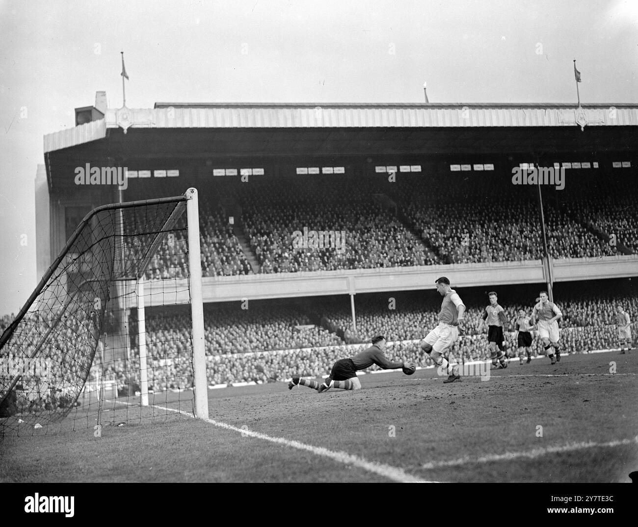 LEWIS HA BATTUTO DI POCO AD HIGHBURY Una veloce immersione di HARRY SEARSON , portiere del Leeds United , e strappa la palla quasi ai piedi del REG LEWIS , Arsenal dentro a sinistra , durante il sesto round della Coppa di calcio Association all' Arsenal Stadium di Highbury , Londra . L'azione è riuscita ad un calcio di punizione da parte di Cox dell'Arsenal . 4 marzo 1950 Foto Stock