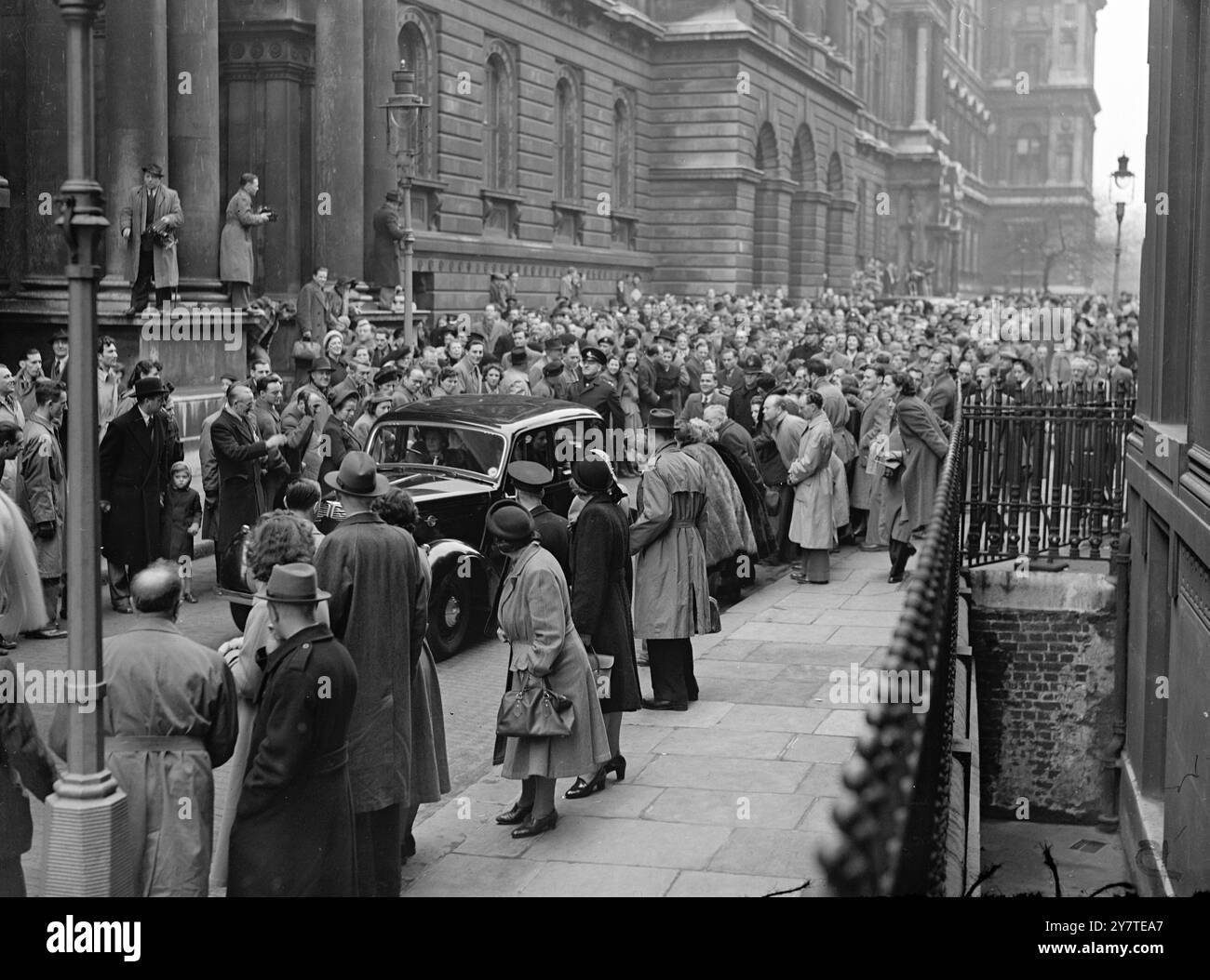 ATTLEES ' CONTINUA ' con la signora Attlee di nuovo al volante, e folle che spingono dietro l'auto, Mr. Attlee guida da Downing Street a Chequers dopo la lunga consultazione mattutina con i suoi ministri sulla situazione derivante dalla precaria maggioranza del governo alle elezioni generali. In una dichiarazione rilasciata dopo la riunione, il signor Attlee disse di aver deciso che "è dovere dell'attuale amministrazione continuare a lavorare in carica il governo del re deve essere portato avanti". 25 febbraio 1950 Foto Stock