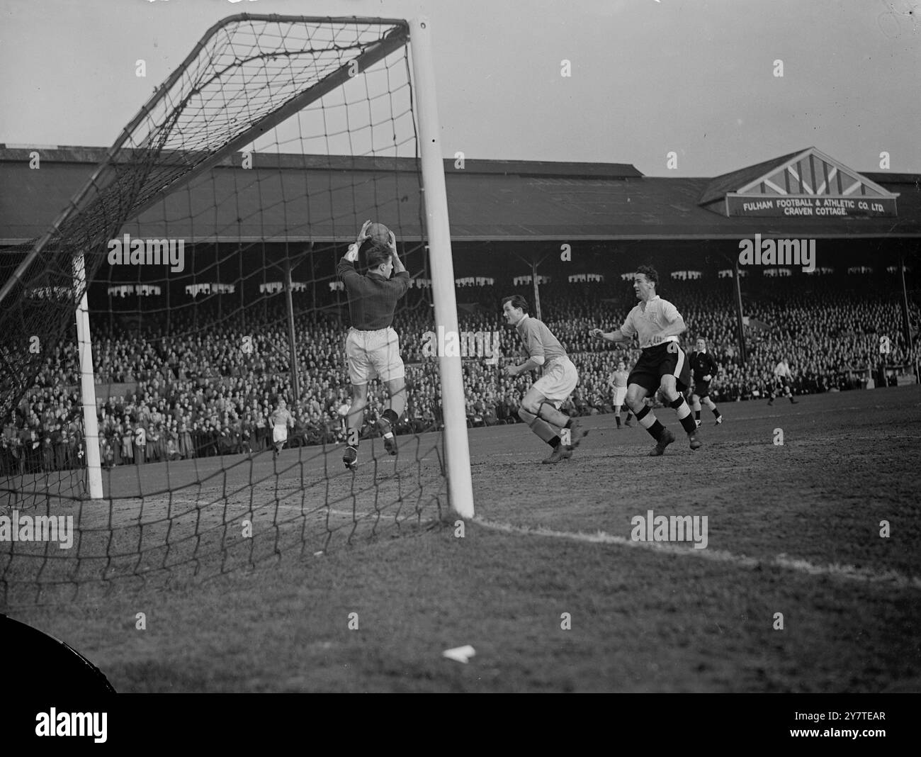 IN ALLERTA George Farm, portiere dei Blackpool, salta da un attacco guidato da Jimmy Jinks, il centro avanti del Fulham (a destra) mentre il centro riserve Johnny Crosland è pronto per le emergenze (centro) durante il match di First Division al Craven Cottage di oggi (sabato, il Blackpool, che ha schierato un certo numero di riserve, è stato battuto di un zero. 18 febbraio 1950 Foto Stock