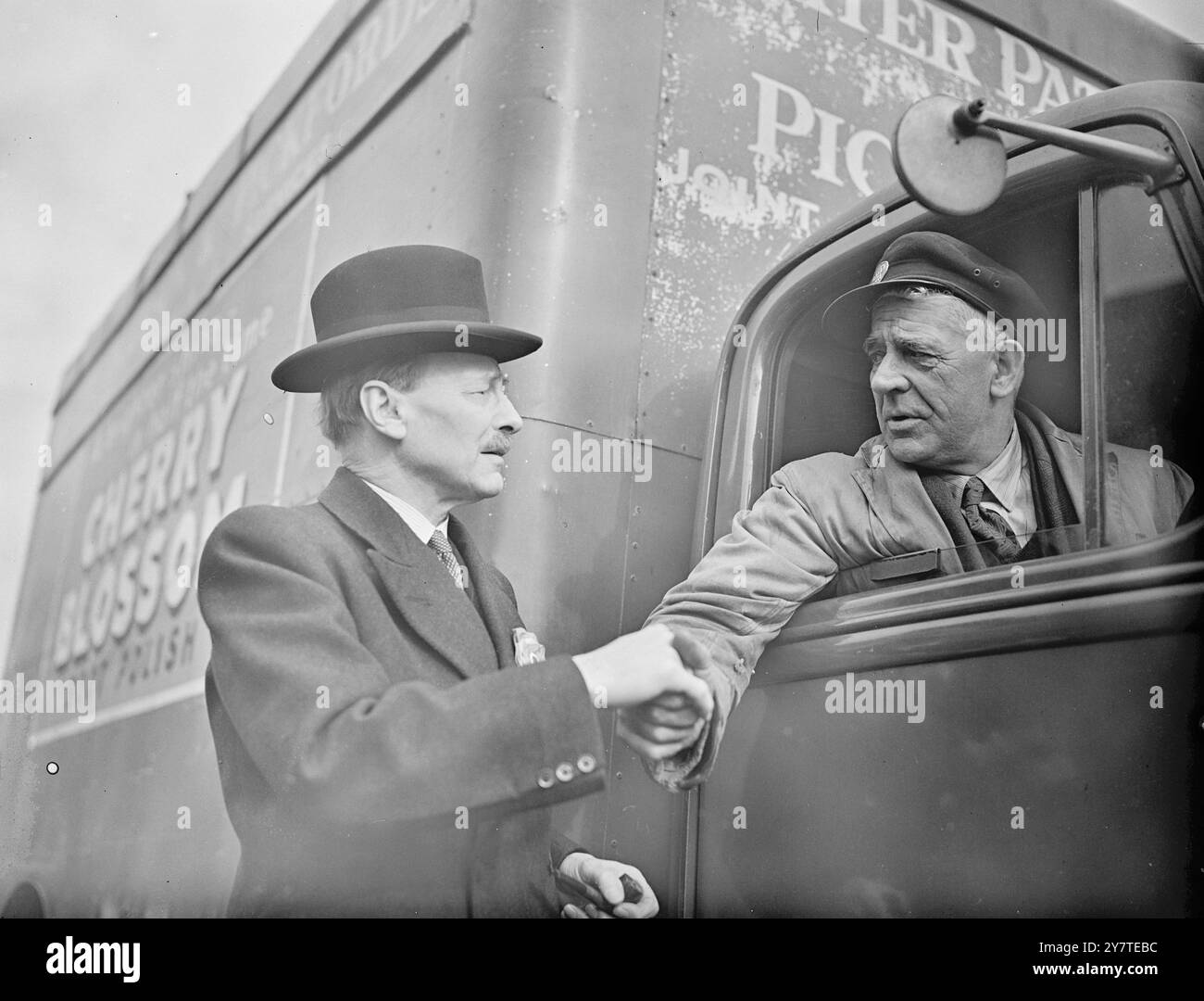 ' SPERO DI ESSERE DI NUOVO AL POSTO DI GUIDA'. Il Premier Clement Attlee stringe la mano al camionista Mr. E.Burk della Forests Row, che ha fatto durante un tour della sua circoscrizione a Walthamstow West, East London, oggi. 22 febbraio 1950 Foto Stock