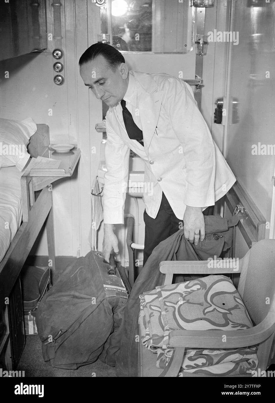 GLI UFFICIALI DEL CANTIERE CERCANO UN UOMO RICERCATO A BORDO della NAVE DI LINEA il 3 FEBBRAIO 1950 osservando i bagagli lasciati a bordo dell'"Ile de France" da Edouard Gavron di 25 anni, ricercato dagli ufficiali di Scotland Yard che salparono attraverso una burrasca da Southampton per salire a bordo della nave di linea americana. I detective hanno pettinato cabine e ponti, ma non sono riusciti a trovare Gavron, che si dice abbia commesso falsi in diversi paesi. Si dice che siano coinvolte somme per un totale di 50.000 sterline. In una cabina sul ponte "B" a bordo del transatlantico, un ufficiale di Scotland Yard ha trovato una valigia blu fatiscente, un kitbag verde dell'esercito americano e un valise verde. La polizia francese, che aveva un Foto Stock