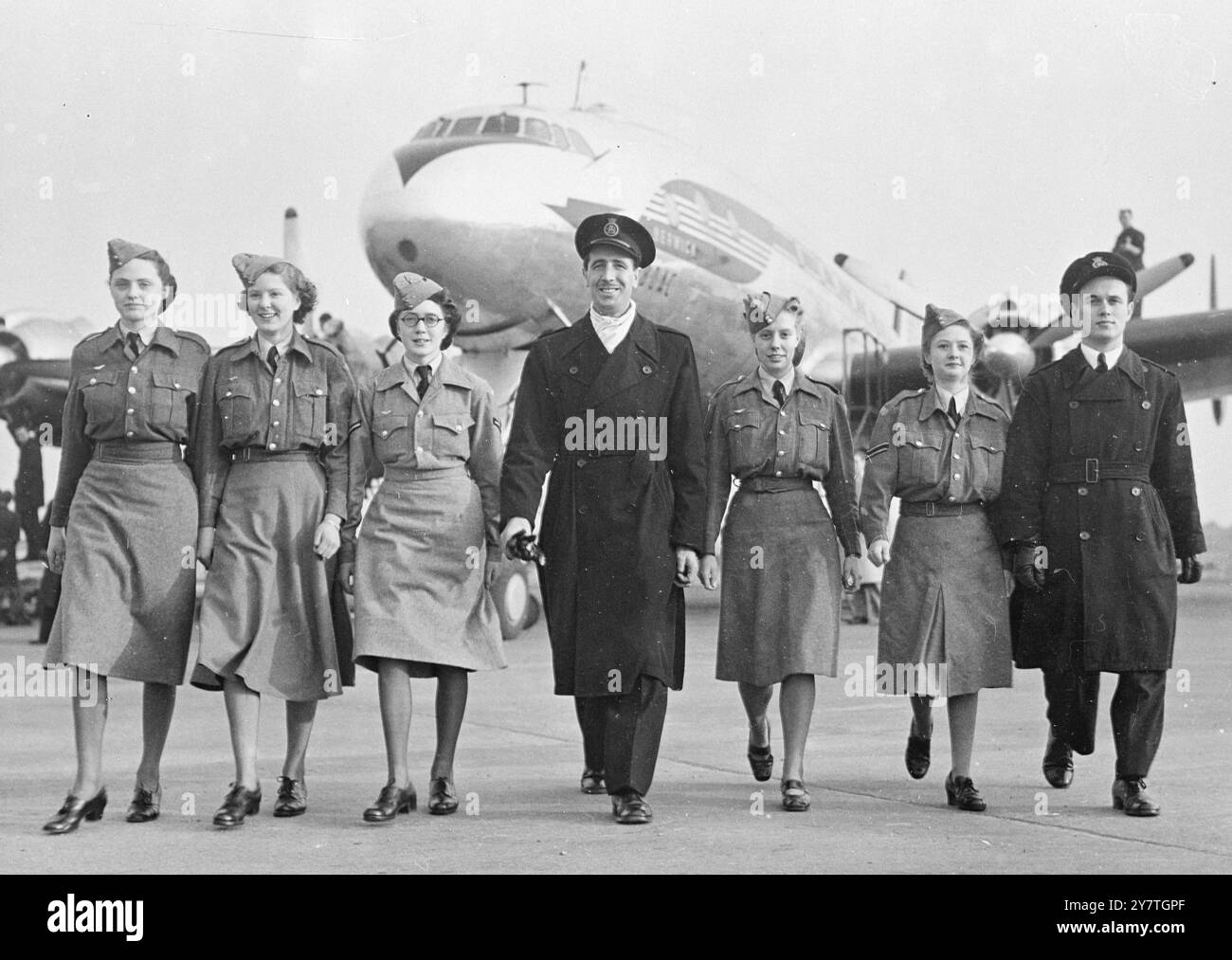 OCCHI SUL PREMIO questi membri del Junior Air Corps, sorridenti con determinazione, attraversano il piazzale dell'aeroporto di Londra con gli steward della British Overseas Airways dopo aver visitato un aereo di linea costellato. L'aereo è simile a quello in cui un membro fortunato del corpo volerà in Australia all'inizio del prossimo anno. Il volo, di B.O.A.C./ Qantas, è il premio offerto dal corpo al vincitore del concorso aperto a tutti i membri di età compresa tra 19 e 25 anni. 3 novembre 1949 Foto Stock