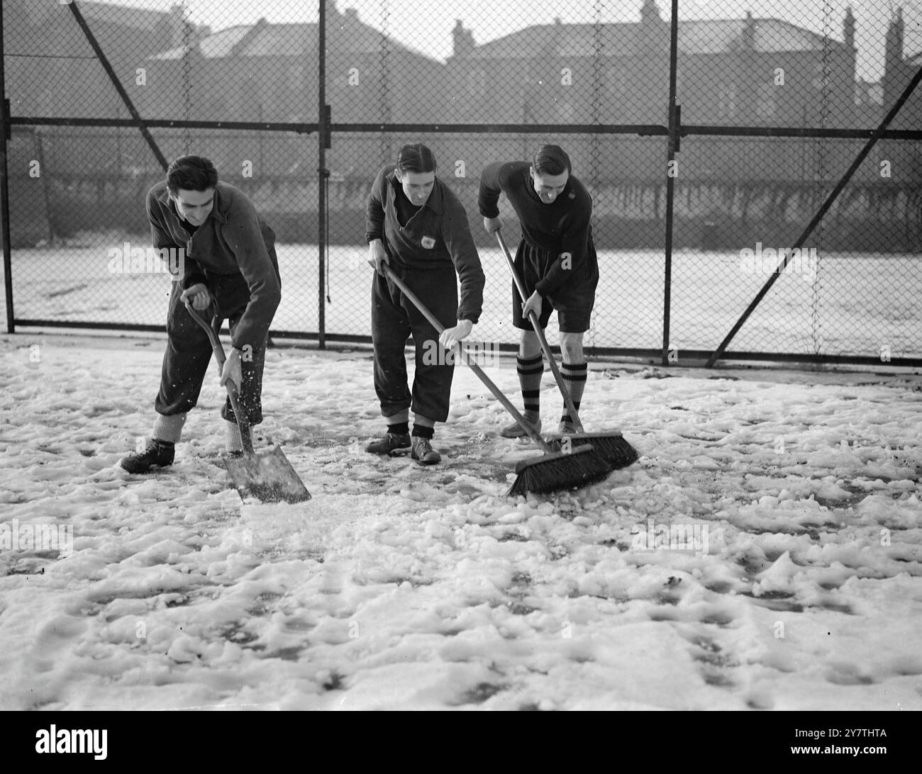 L' arsenale apre la strada allo scontro di Coppa i giocatori dell' Arsenale Colin Grimshaw , Jimmie Logie e George Swindin ( da sinistra a destra ) liberano la neve e il ghiaccio dalla bocca di porta sul loro campo di allenamento a Highbury , Londra quando i membri della squadra erano fuori allenamento per il terzo turno di fa Cup contro il Carlisle . 3 gennaio 1951 Foto Stock