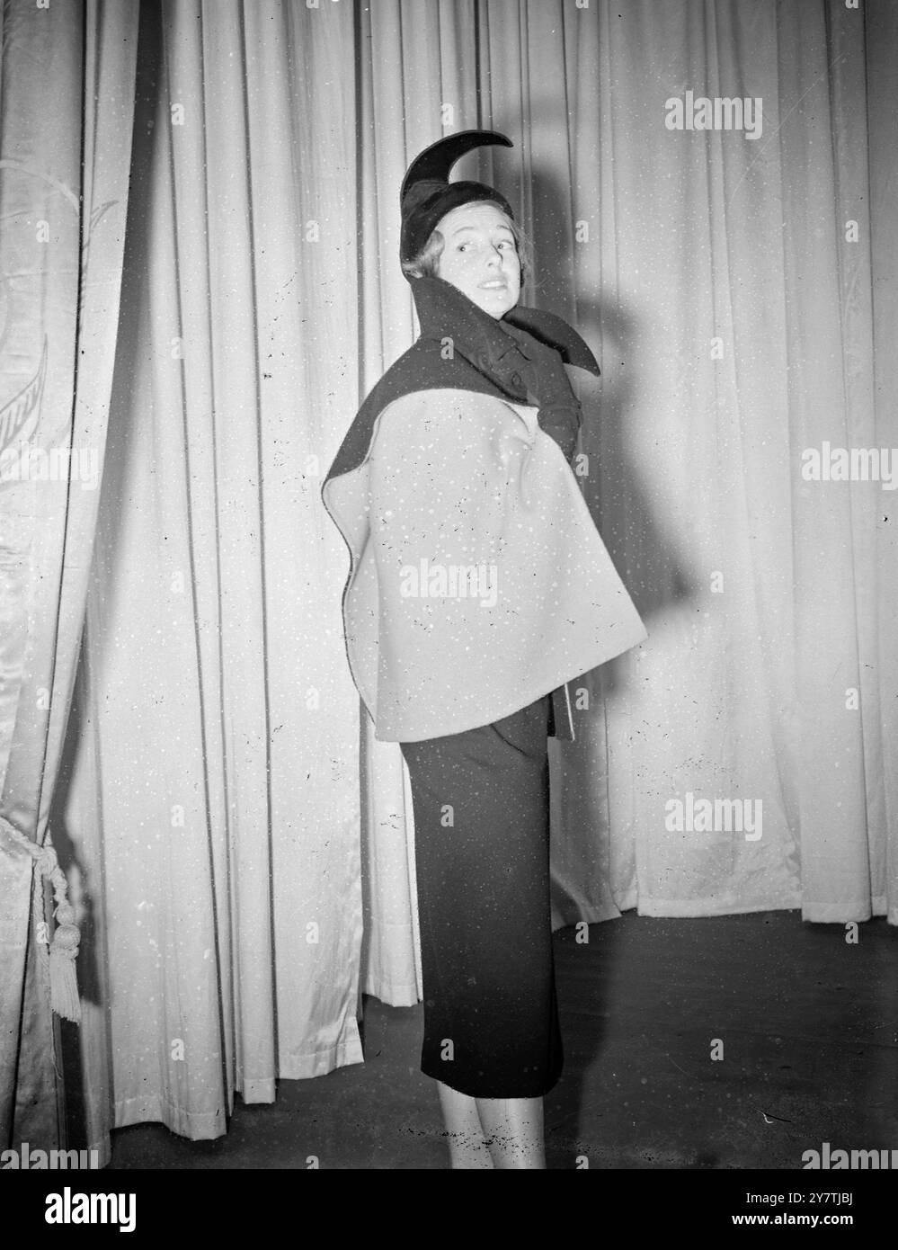 Le più importanti case di moda e fabbriche tessili di oltre una dozzina di paesi hanno inviato i loro prodotti migliori a Londra per essere esposti nella prima sfilata internazionale di tessuti e moda al Savoy Hotel di Londra , organizzata dalla Segreteria Internazionale della lana , la mostra ' International Wool' è ritenuta la più grande del suo genere mai tenuta, con circa 250 tessuti di lana in esposizione. Spettacoli fotografici: Una delle modelle francesi alla mostra . Abito in lana nera con cappotto reversibile nero e rosso di Robert Piquet .20 settembre 1949 Foto Stock